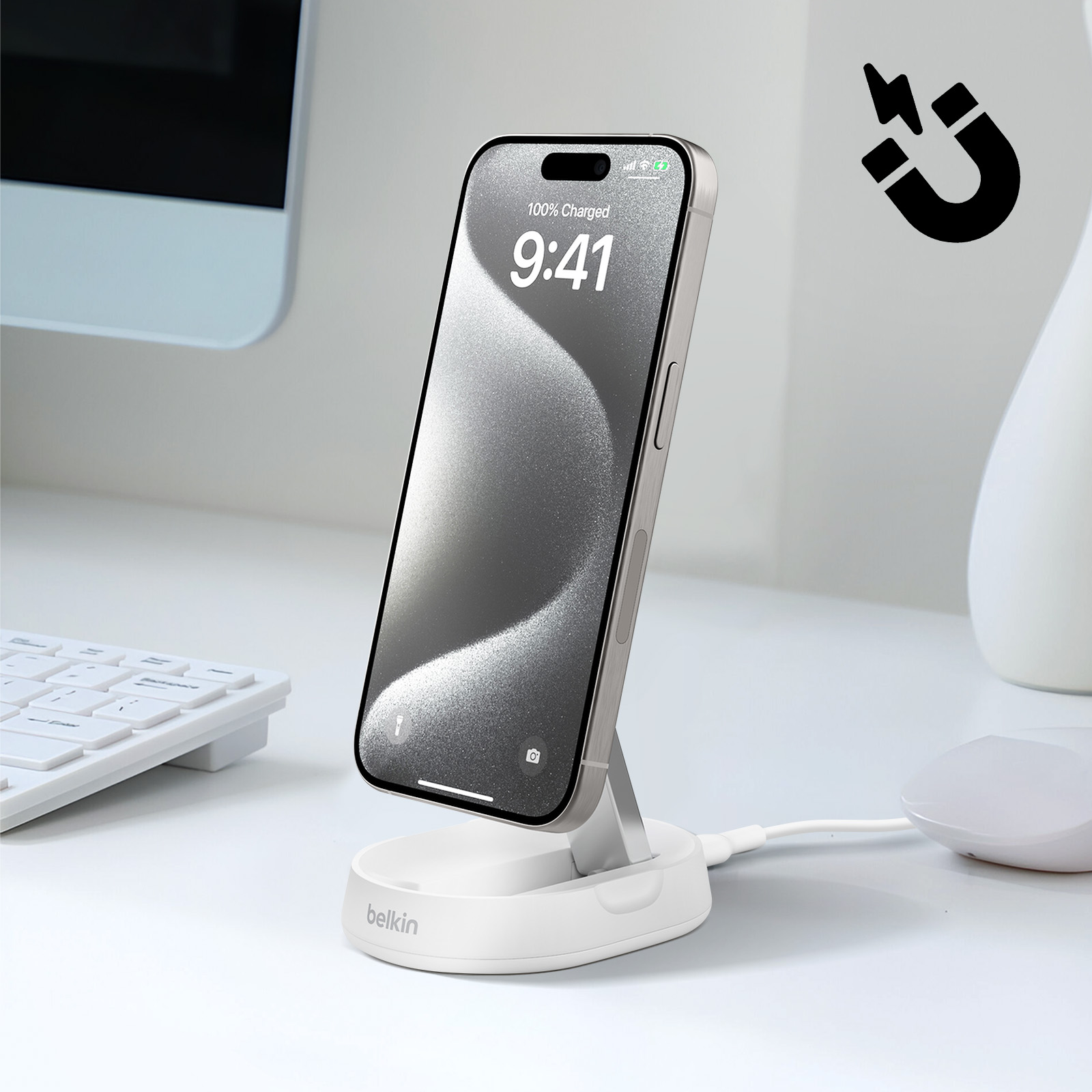 Ein Telefon, das auf einem weißen Ständer geladen wird, und ein Magnetzeichen.