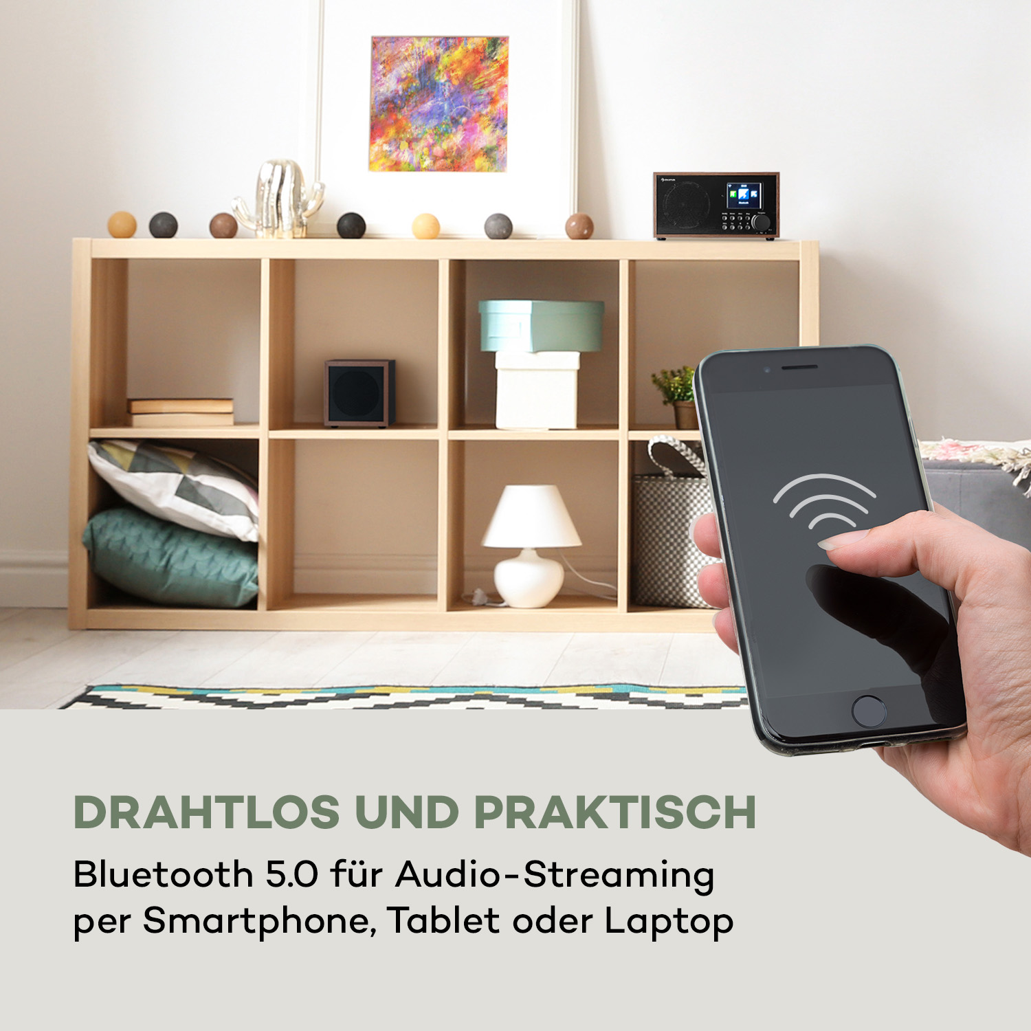 Eine Person hält ein Smartphone mit einem Funksymbol, in der Nähe eines Radios und eines Regals.