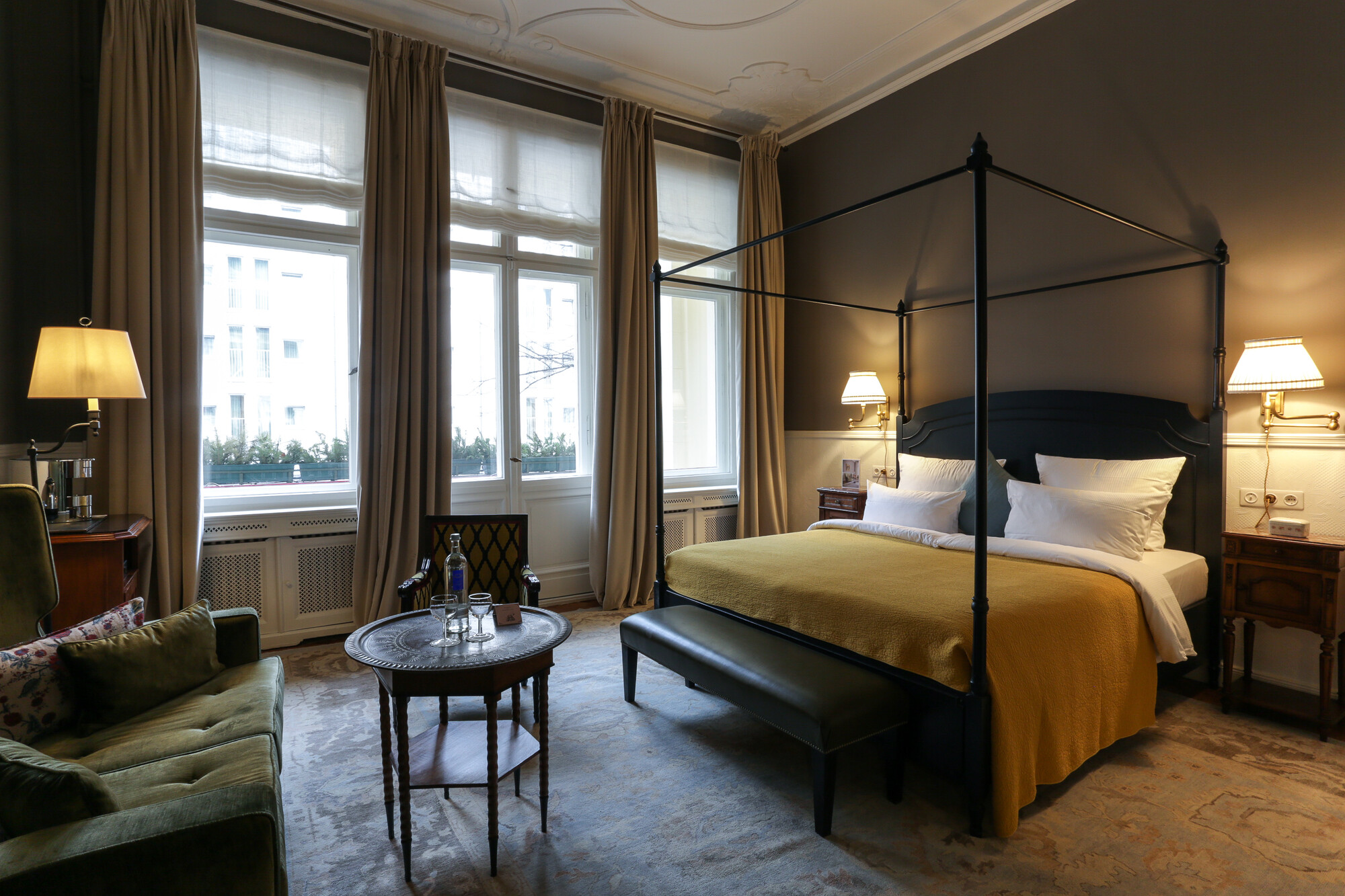 Luksusowa sypialnia z łóżkiem z baldachimem, szafkami nocnymi i sofą.