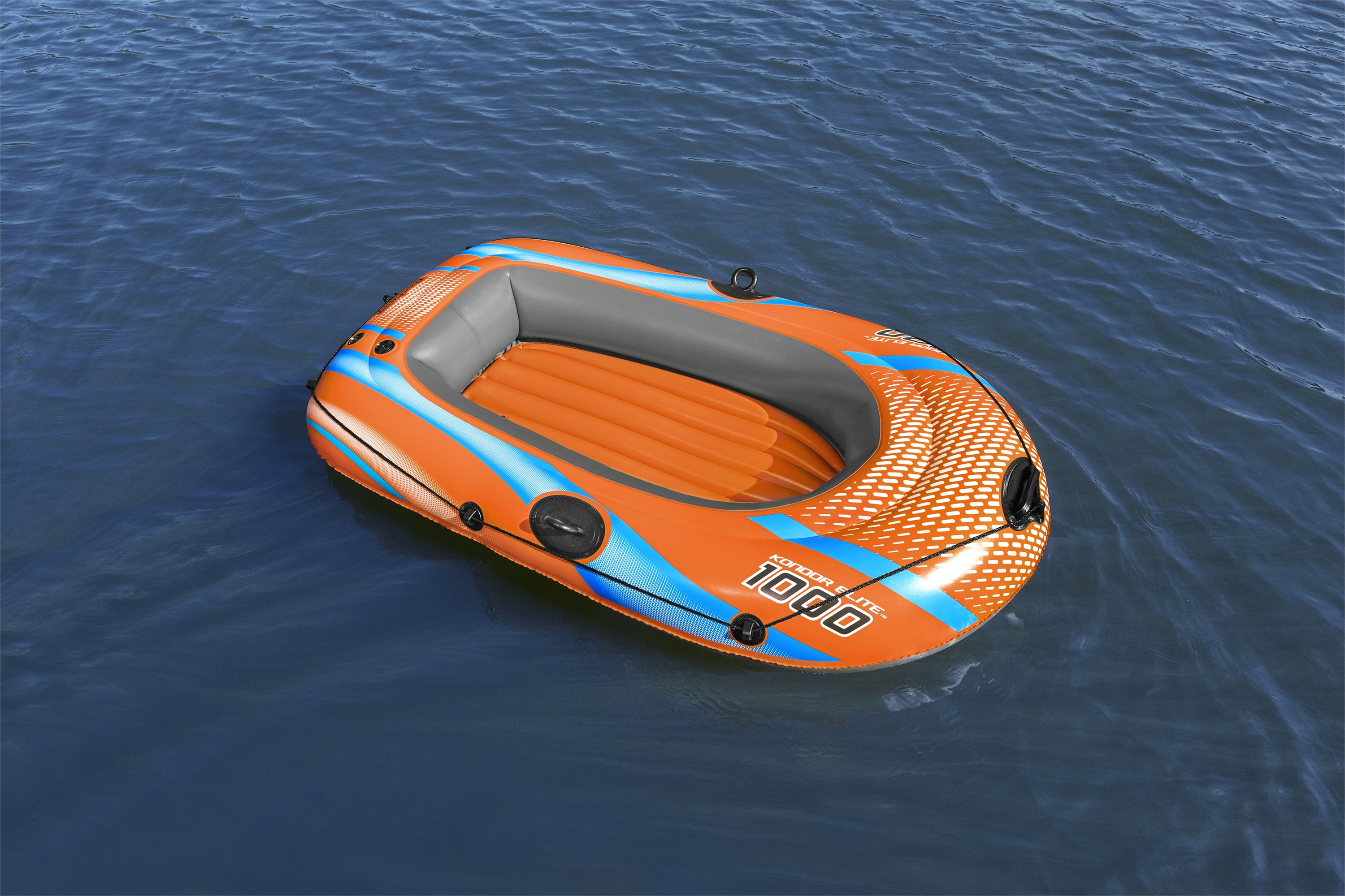 Ein orangefarbenes und blaues Schlauchboot schwimmt auf blauem Wasser. Das Boot hat '1000' drauf.