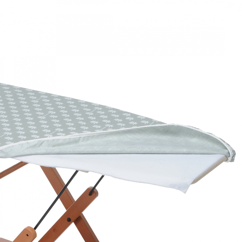 Table à repasser avec une housse à motifs vert clair et blanc. La housse est partiellement relevée.