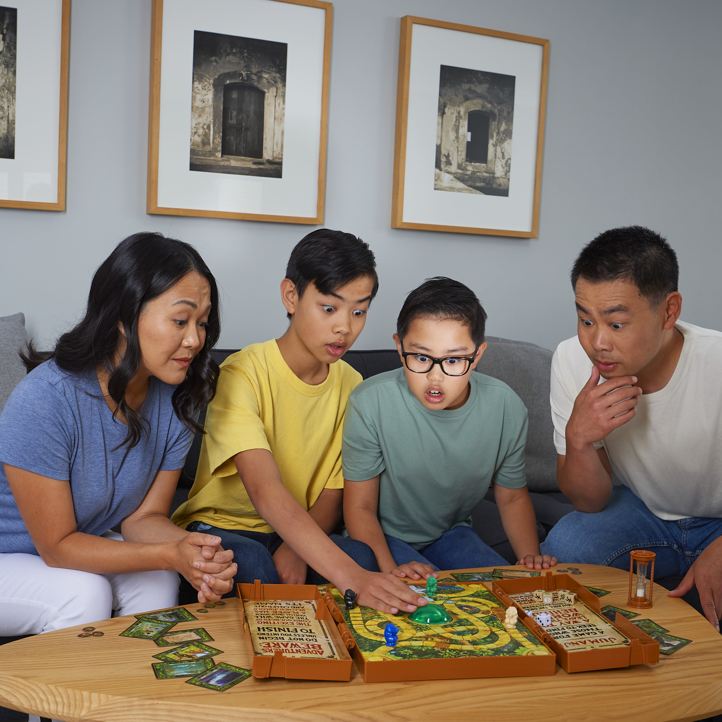 Vier Personen spielen ein Brettspiel. Sie schauen das Spiel mit überraschten Gesichtsausdrücken an.