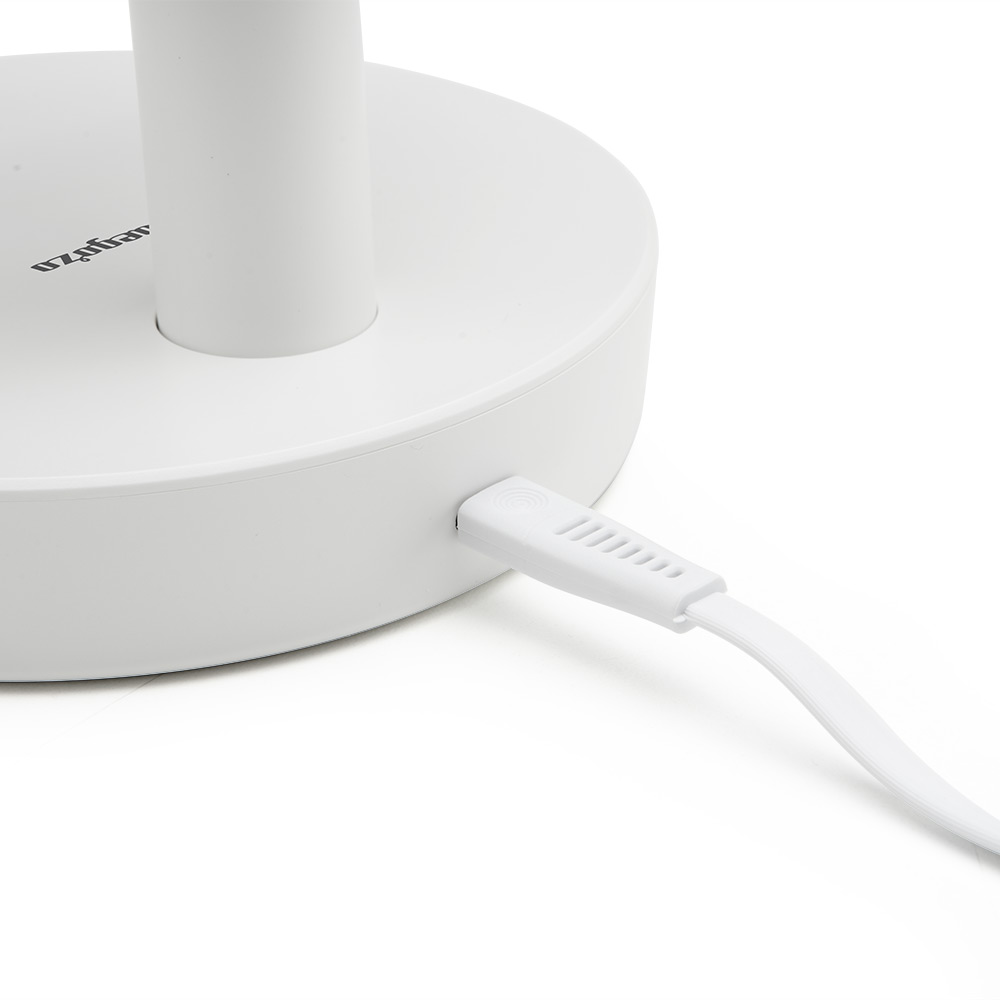 Base blanca con cable blanco conectado a un dispositivo blanco.