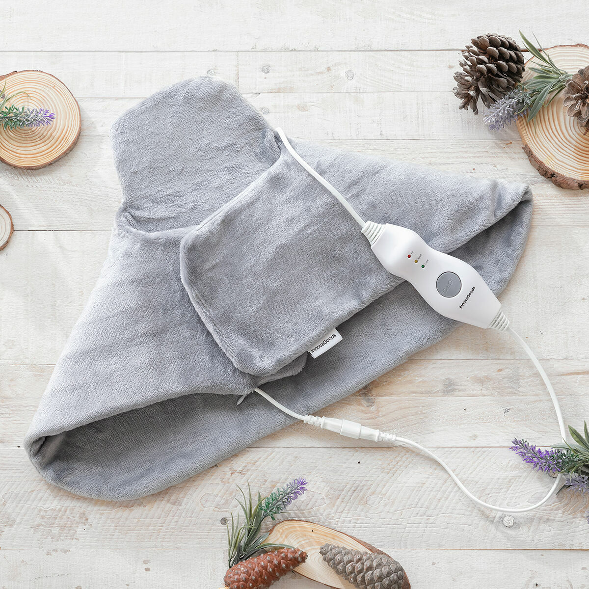 Manta térmica gris con panel de control blanco sobre superficie de madera.