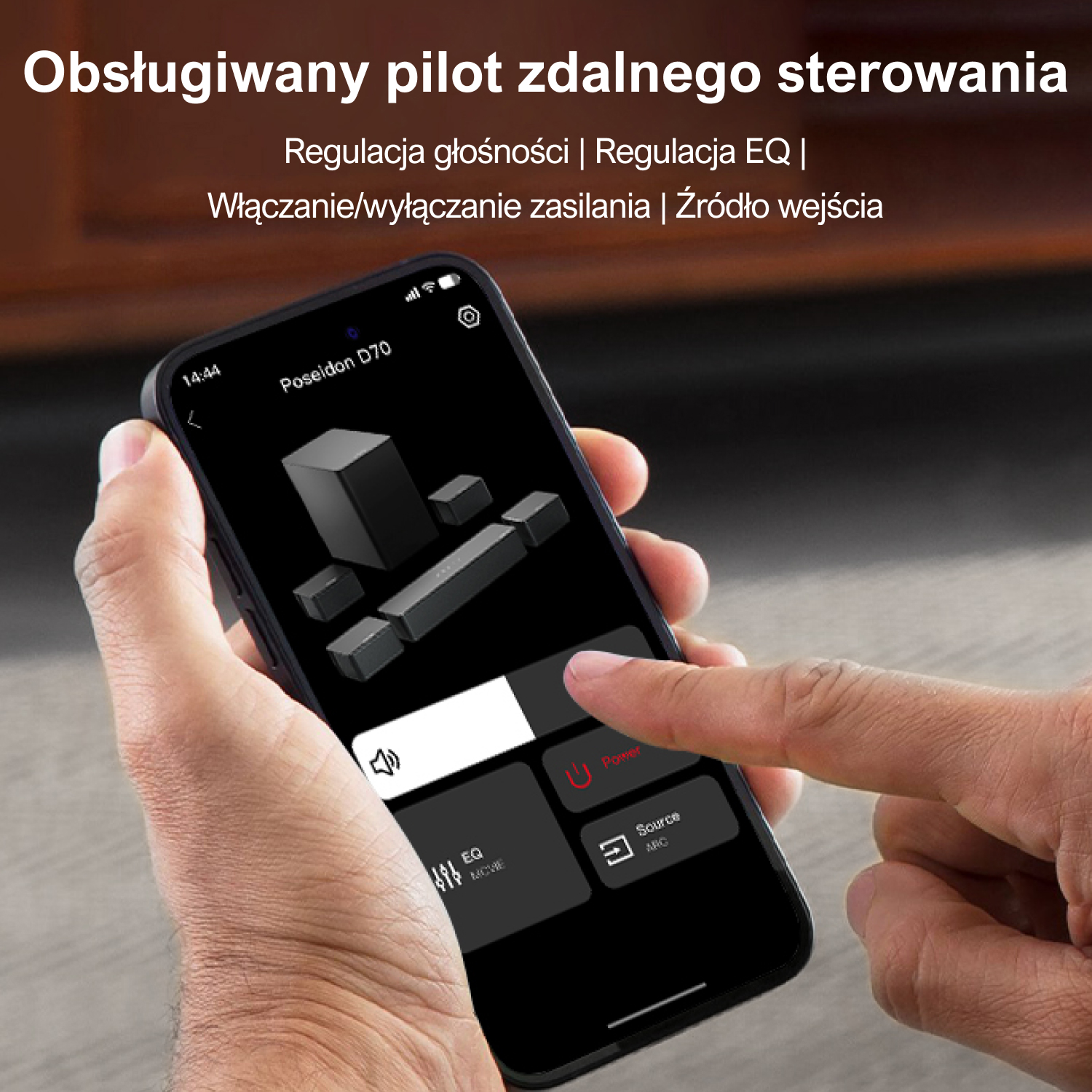Dłoń trzyma telefon pokazujący aplikację do sterowania systemem kina domowego.