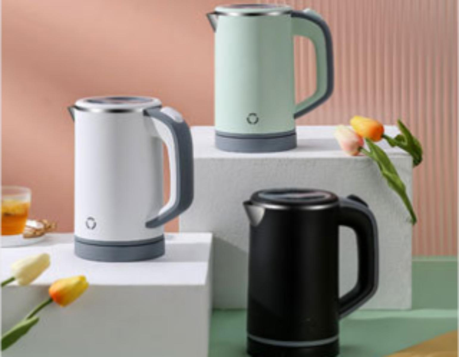 Drei elektrische Wasserkocher. Die Wasserkocher sind weiß, mintgrün und schwarz mit grauen Akzenten. Tulpen stehen auf dem Tisch.