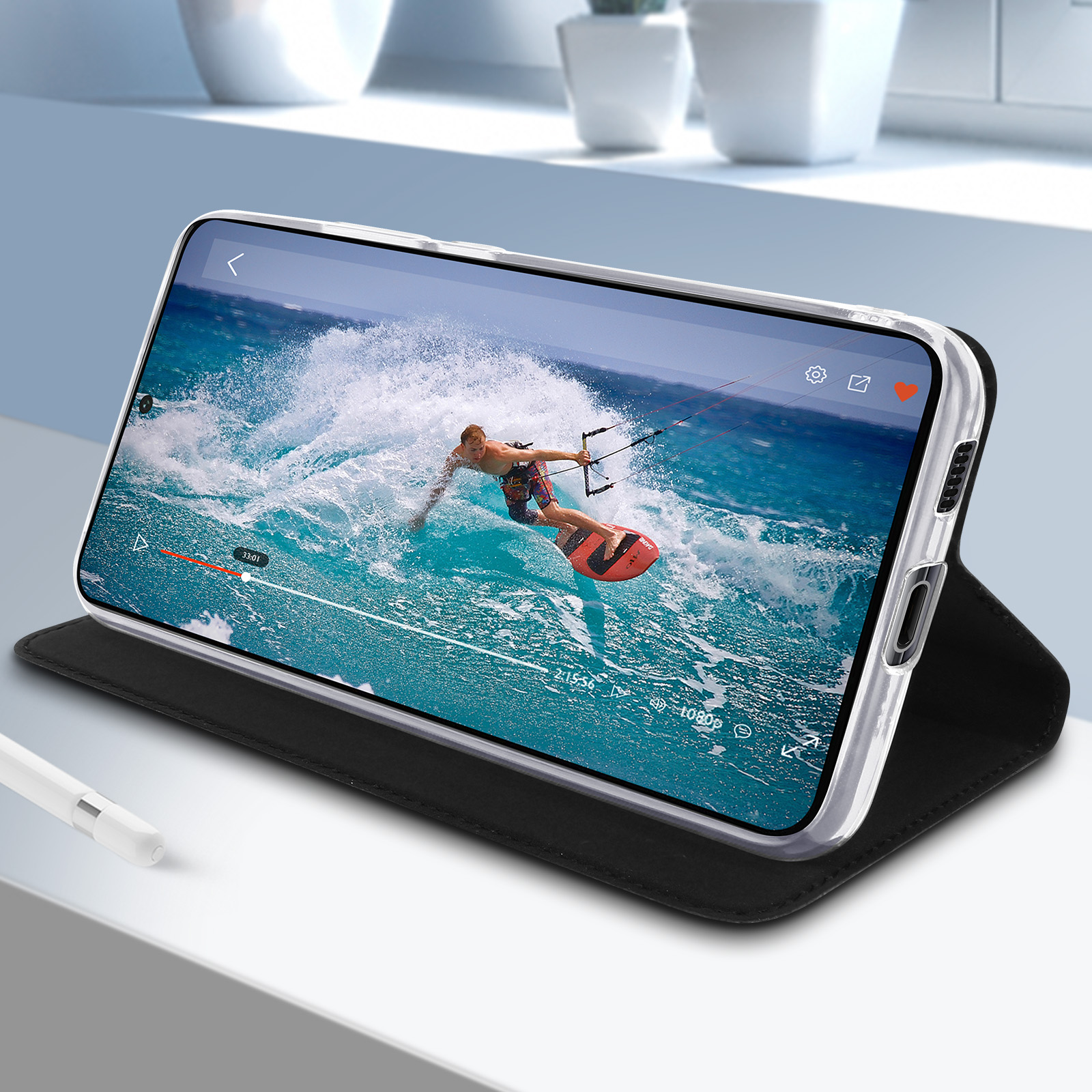Telefono in custodia nera, mostra un video di una persona che fa kitesurf sullo schermo.