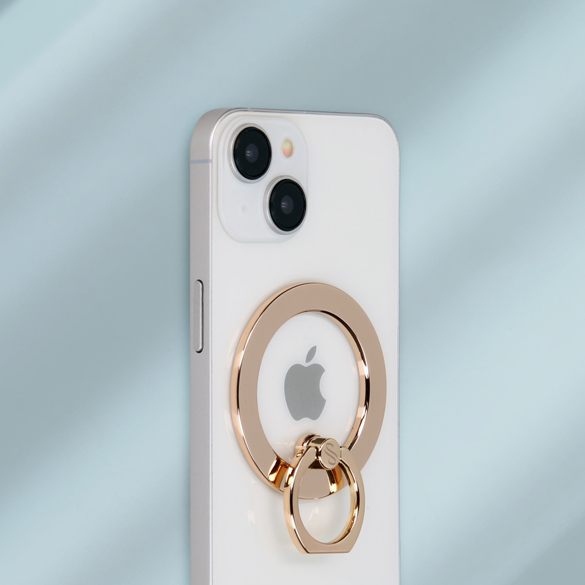 Witte telefoon met een gouden ringhouder aan de achterkant. Blauwe achtergrond.