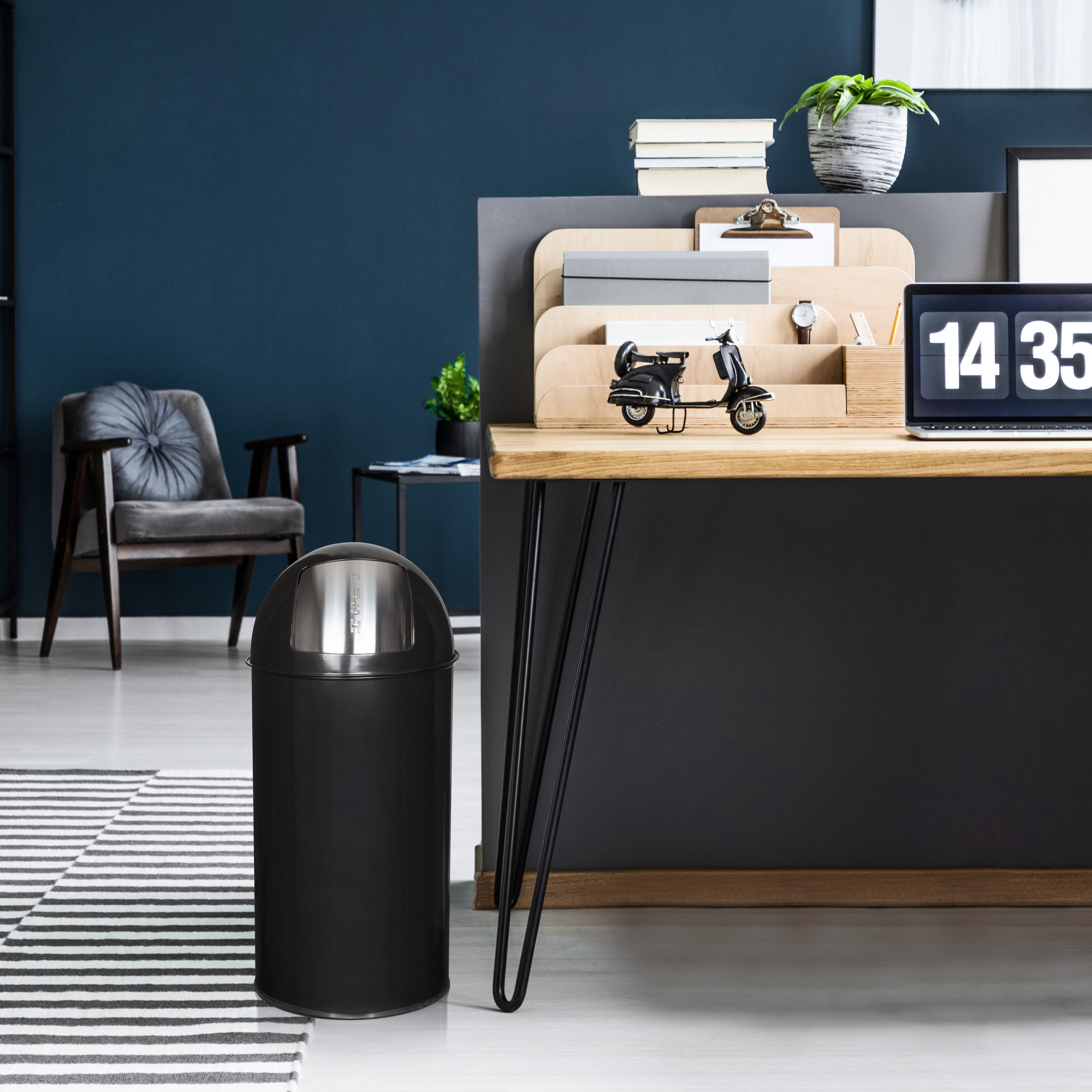 Ein Heimbüro mit Mülleimer, Schreibtisch, Stuhl und Dekoration. Eine Uhr zeigt 14:35.