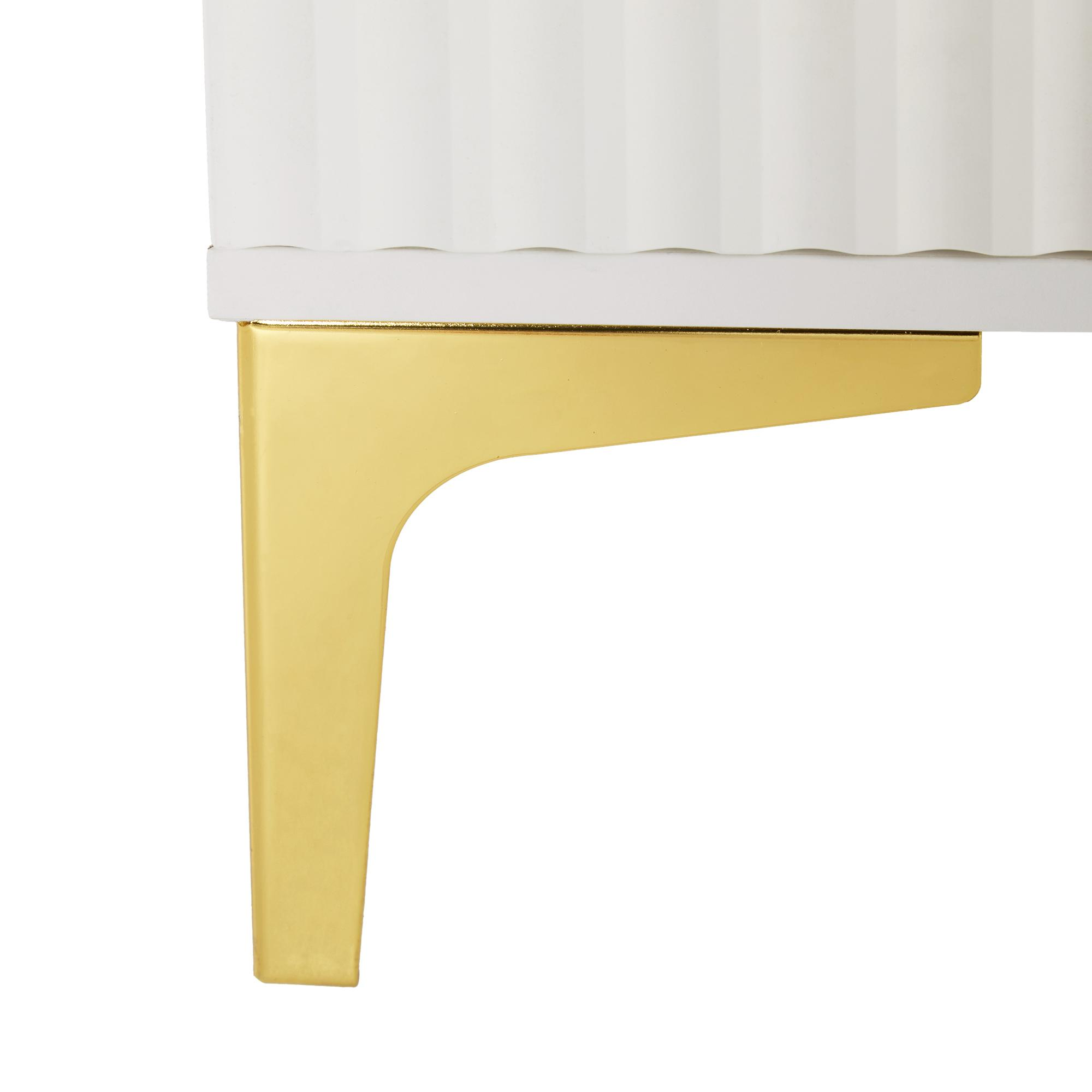 Goldfarbenes Metallbein eines weißen Schranks. Das Bein ist ein geschwungenes, modernes Design.
