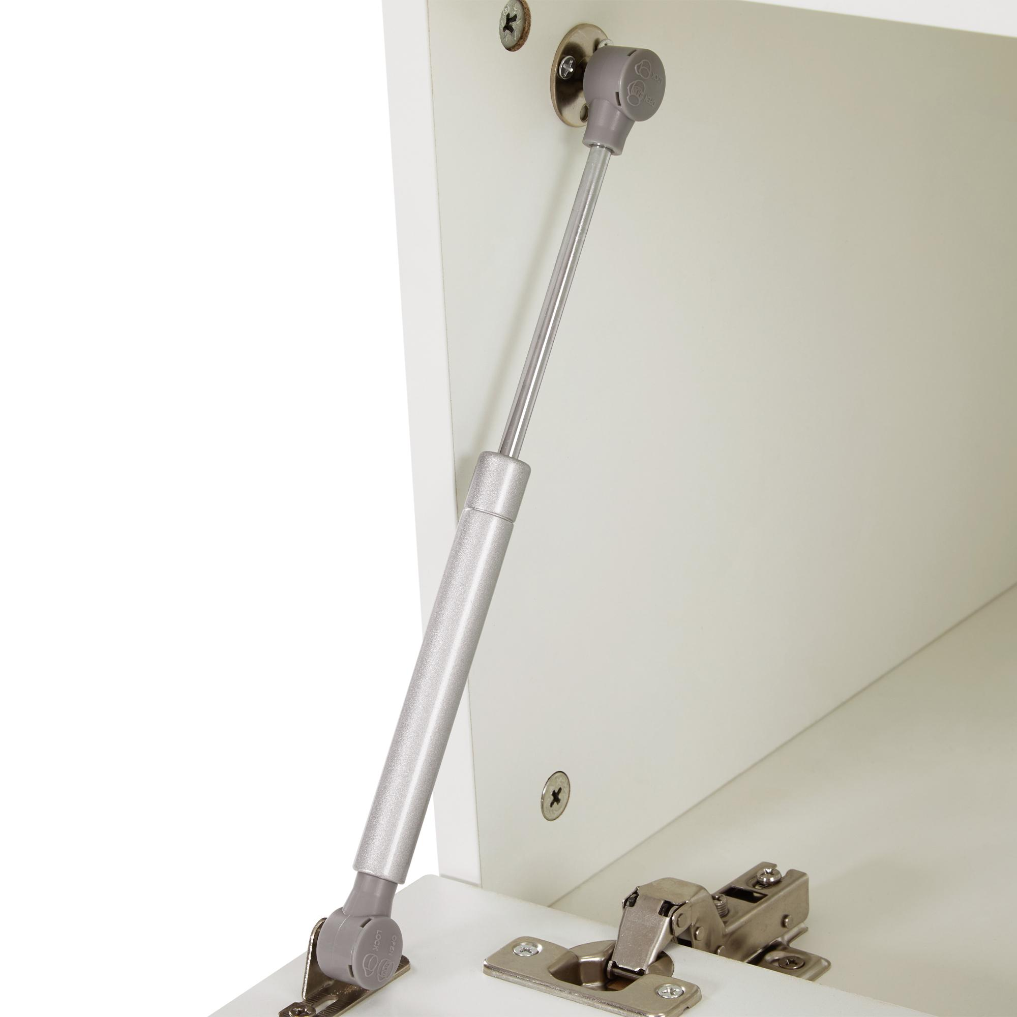 Geöffneter weißer Schrank mit silberner Gasdruckfeder. Scharniere und Schrauben sind ebenfalls sichtbar.