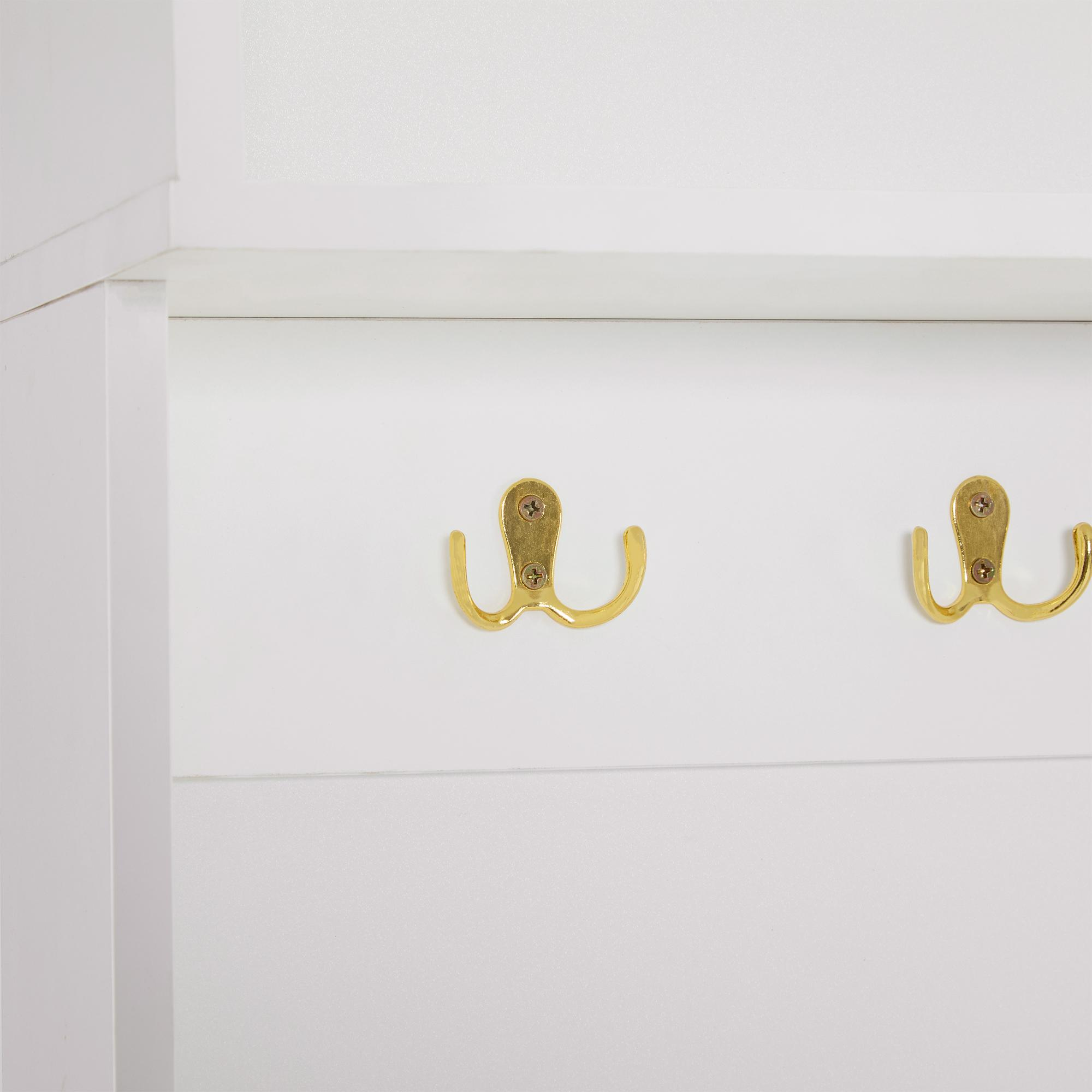 Nahaufnahme eines weißen Schranks mit zwei goldenen Haken. Die Haken sind auf einer weißen Oberfläche montiert.