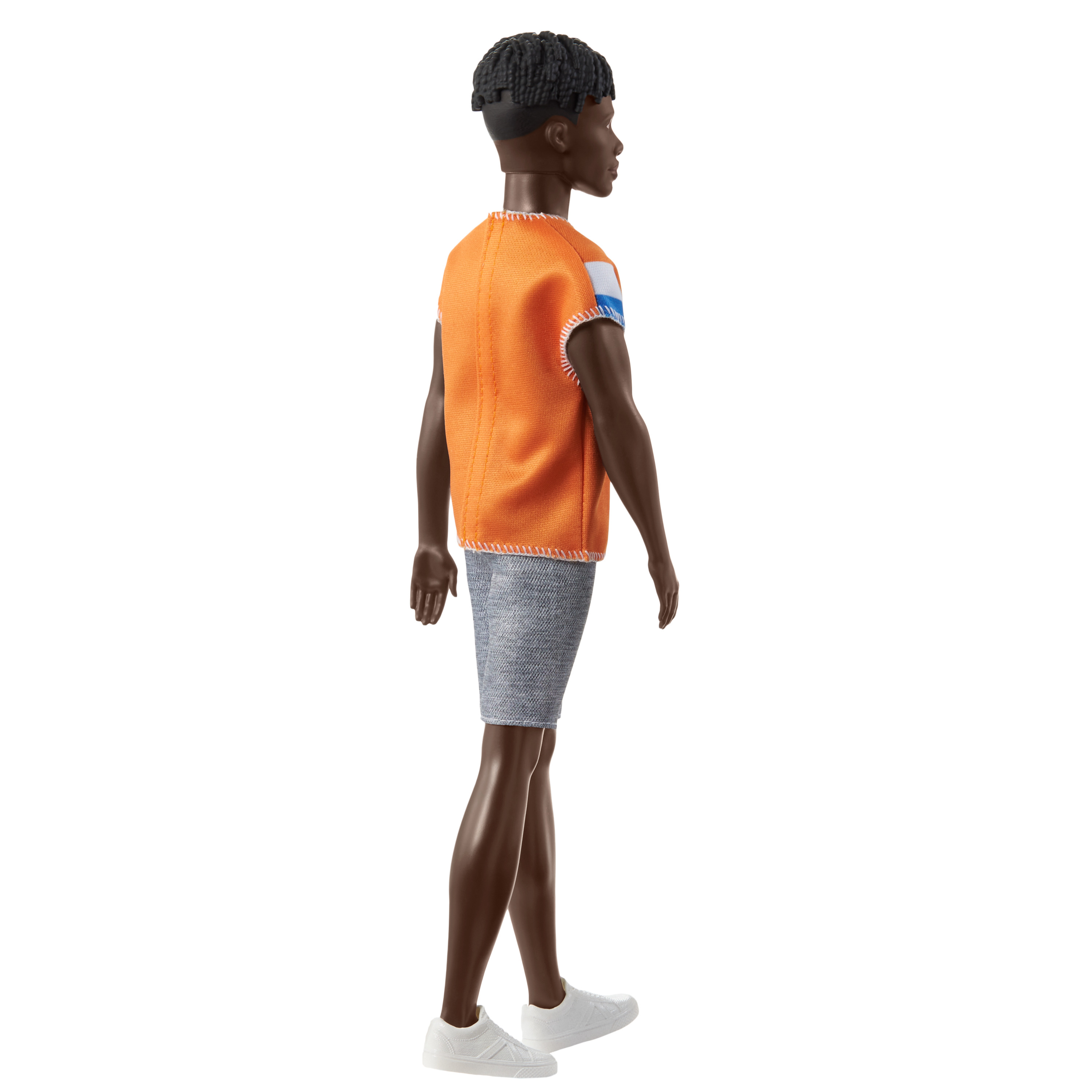 Une poupée noire d'un homme aux cheveux noirs courts. Il porte un gilet orange, un short en jean et des chaussures blanches.