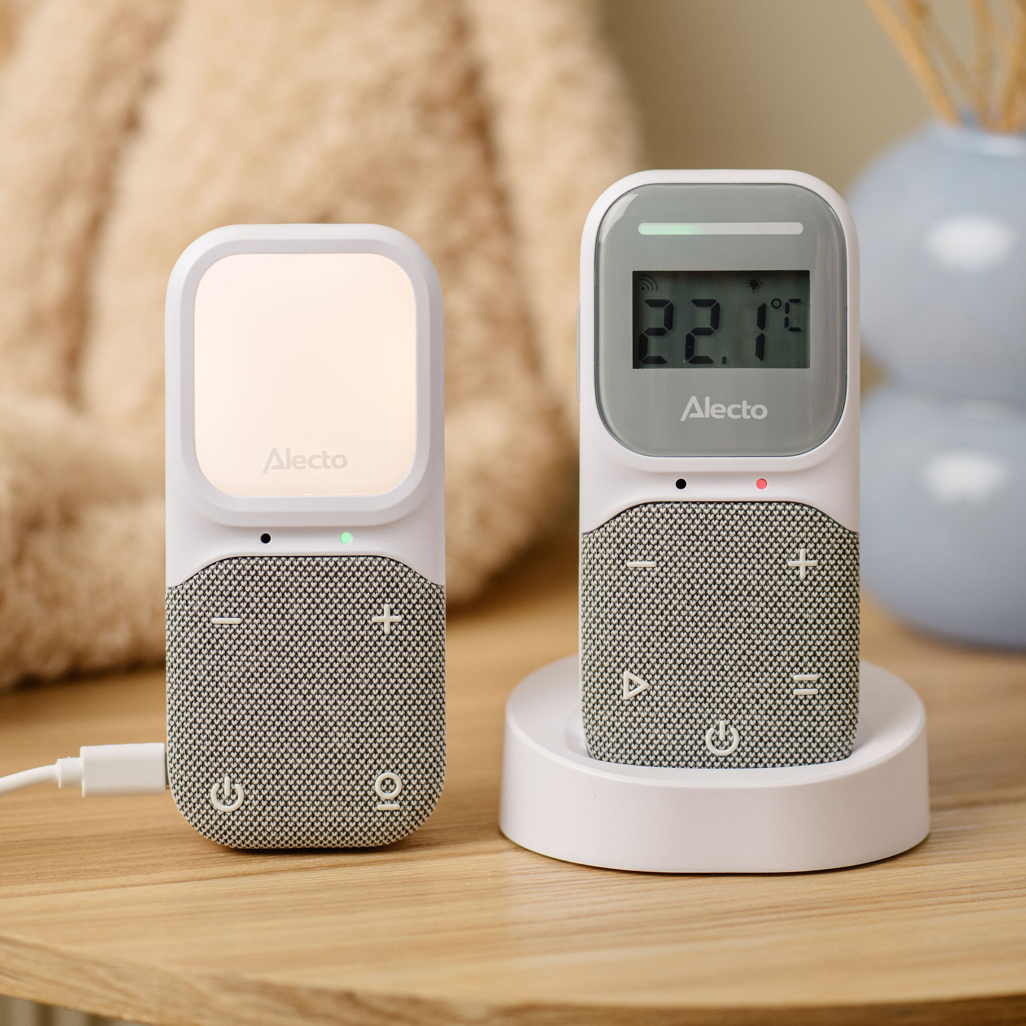 Zwei weiße Babyphone. Eines hat ein Licht, das andere zeigt die Temperatur. Beide haben graue Lautsprecherabdeckungen.