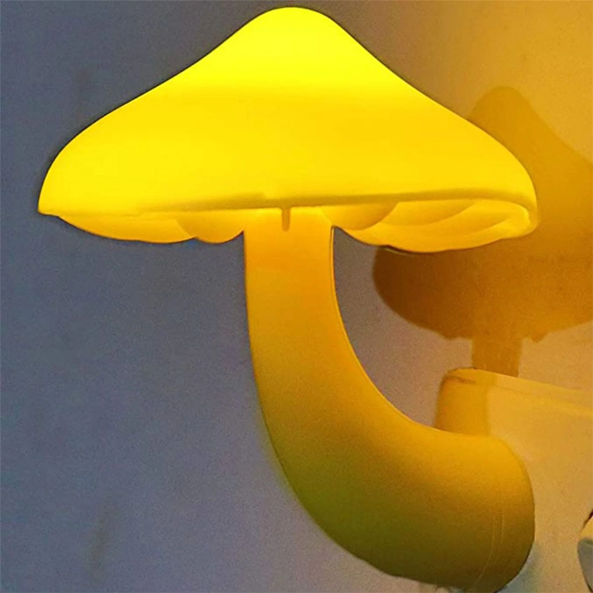 Ein gelbes Pilz-Nachtlicht, das in eine Steckdose gesteckt wird.