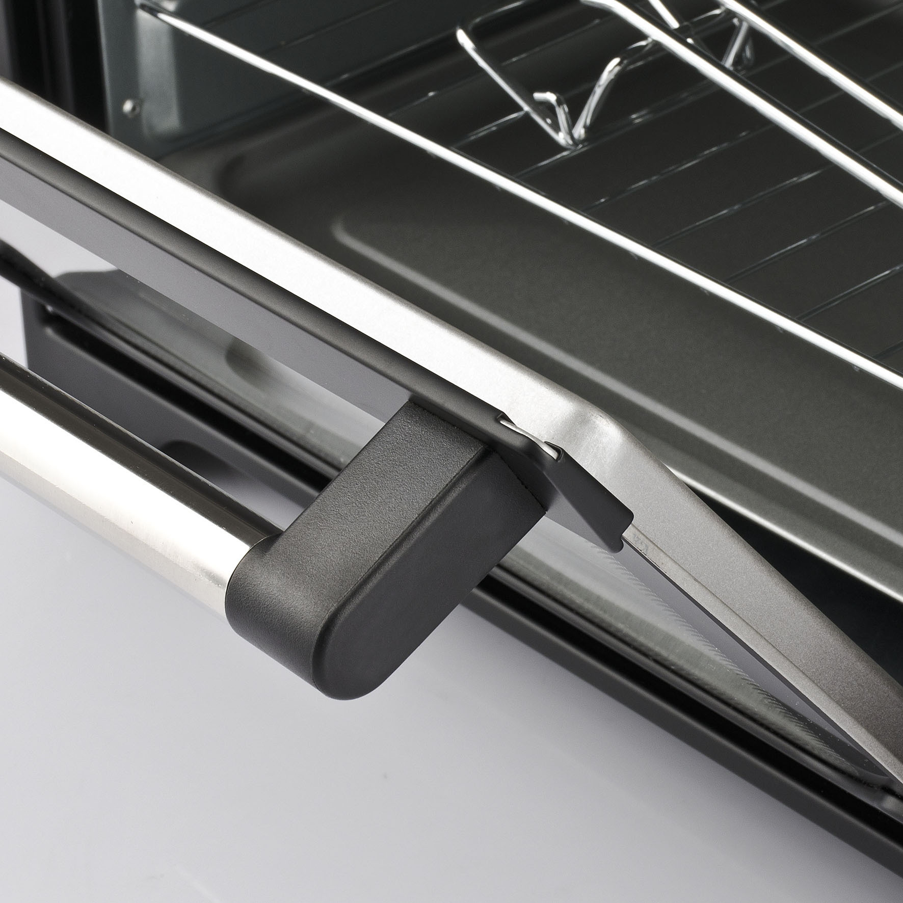 Zbliżenie otwartych drzwi piekarnika, pokazujące uchwyt i wnętrze.