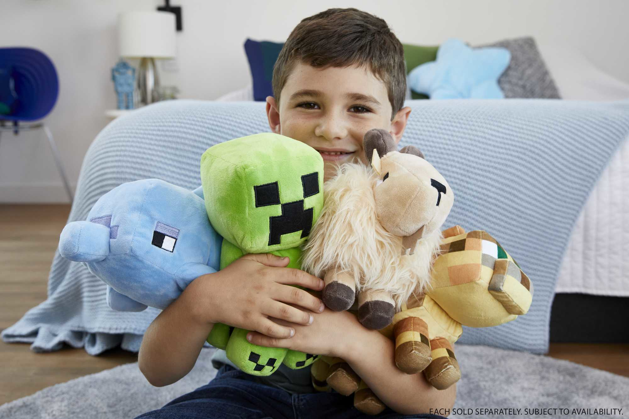Un niño sosteniendo cuatro peluches de Minecraft: un delfín, un creeper, una oveja y una jirafa.