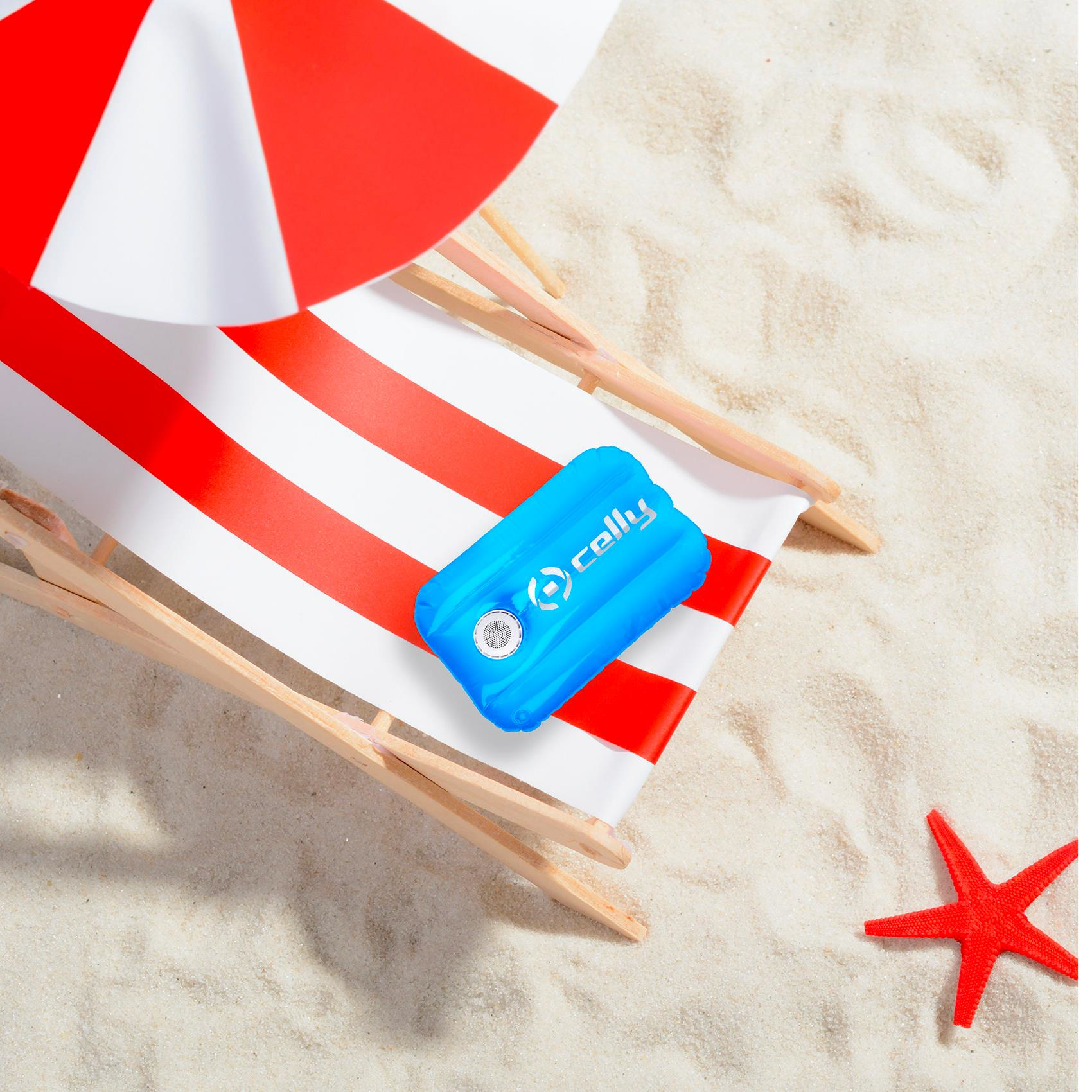Scena sulla spiaggia: Altoparlante blu su sedia a strisce rosse e bianche. Stella marina rossa.