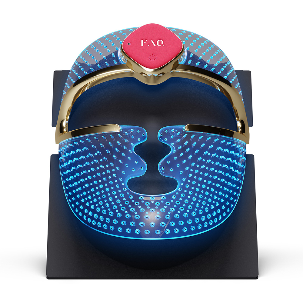 Un masque facial avec des lumières bleues sur un support, avec une base noire et des accents dorés.