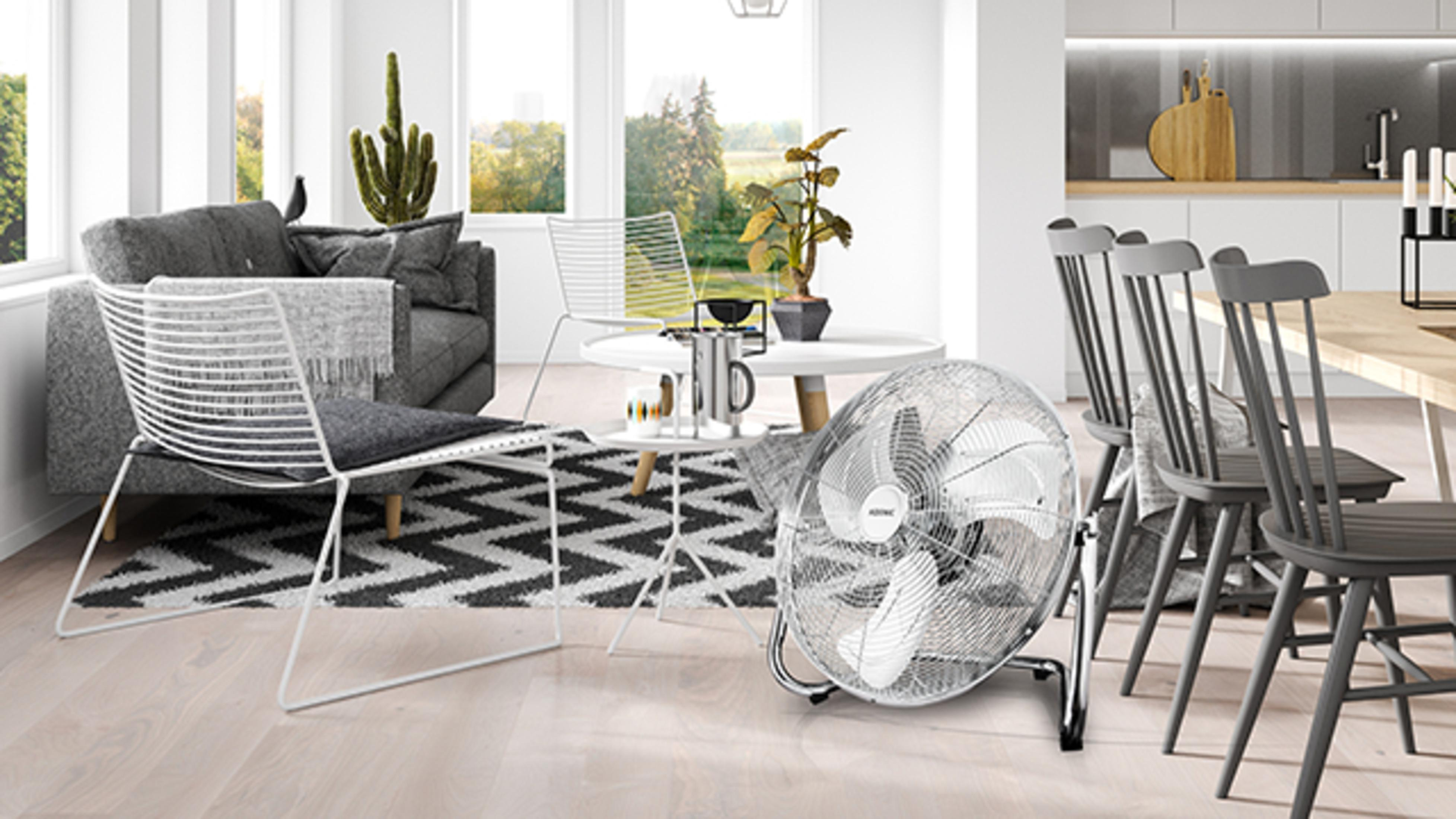 Ein Wohnzimmer mit Sofa, Stühlen, einem Ventilator und einem Tisch mit Pflanzen.