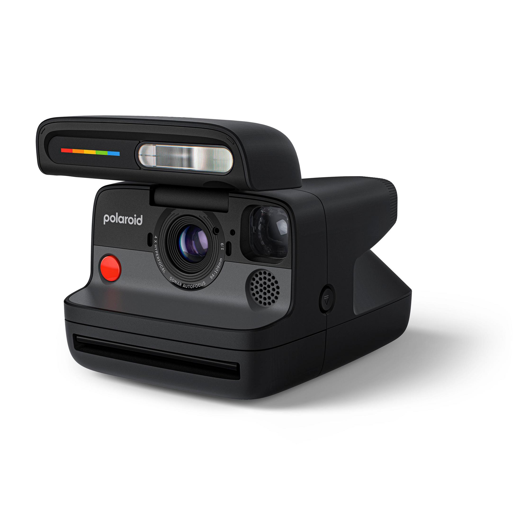 Un appareil photo Polaroid noir sur fond blanc. Bouton rouge et flash.