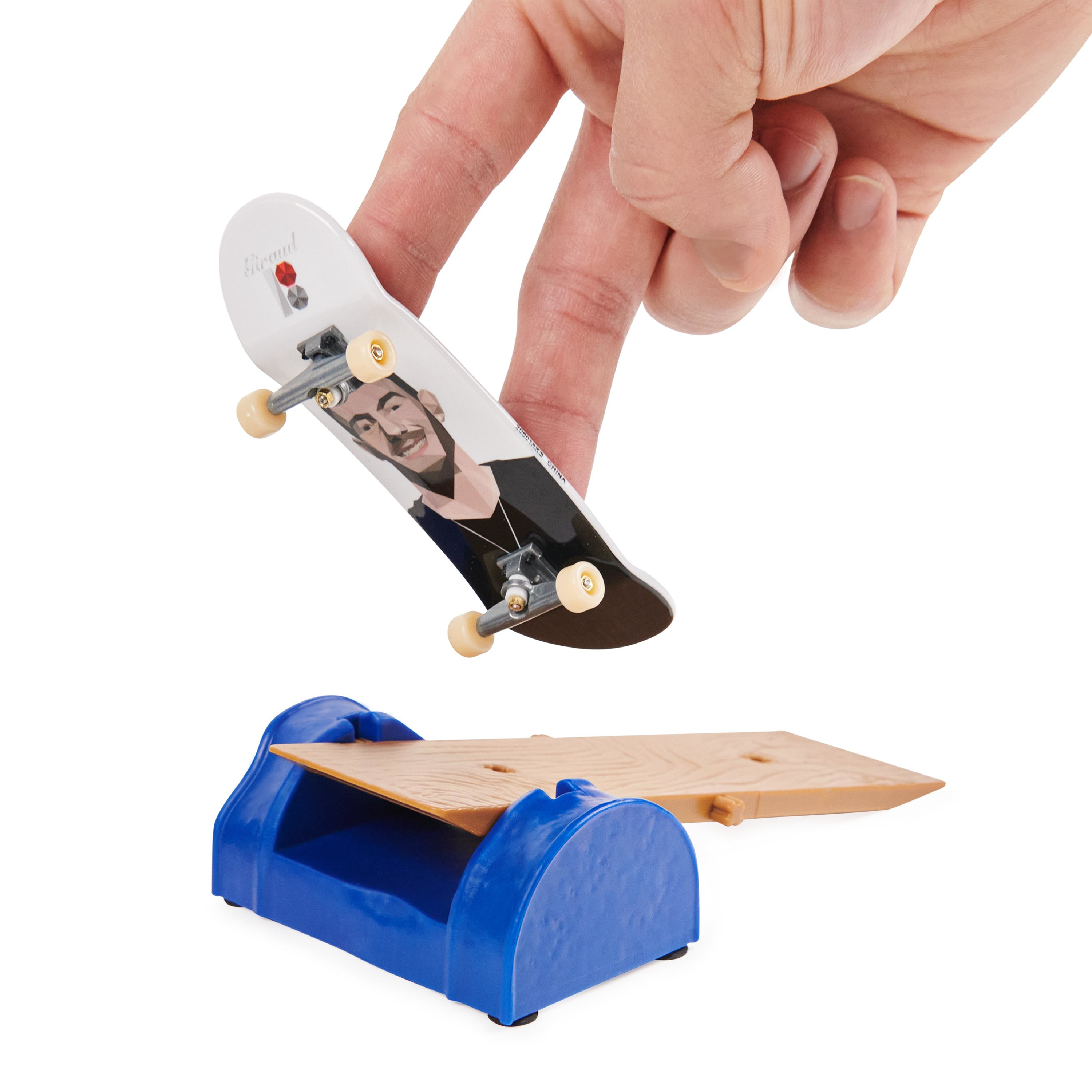 Ein Fingerboard und eine Schiene. Eine Hand hält das Fingerboard über der Schiene.