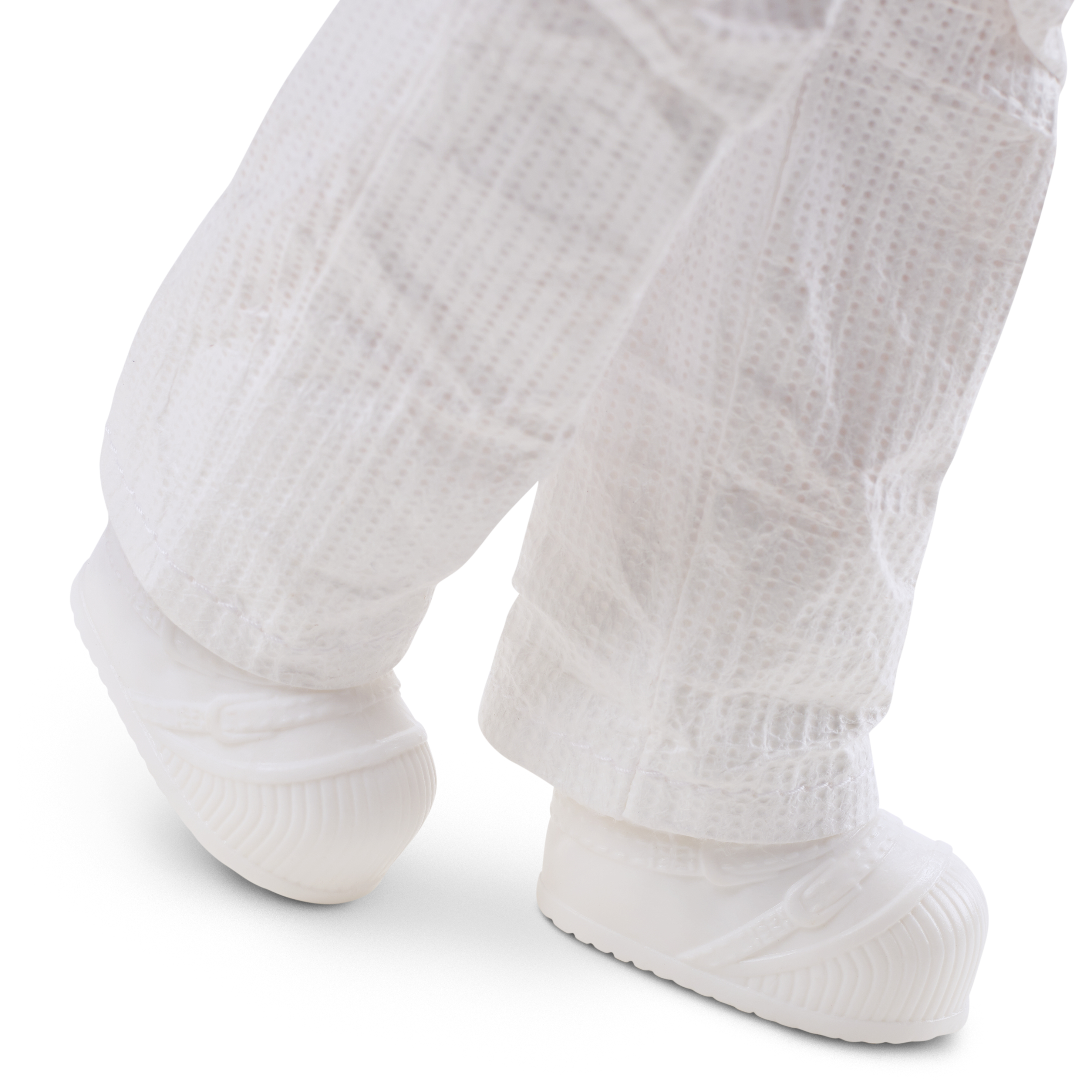 Los pies de una muñeca con botas blancas. La muñeca lleva un traje blanco.