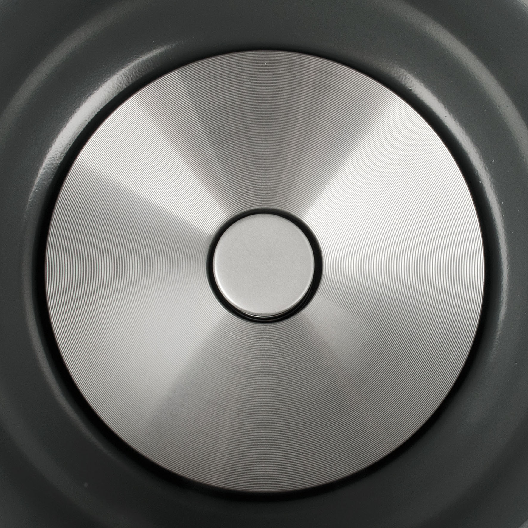 Zbliżenie na szarą podstawę patelni z koncentrycznymi okrągłymi wzorami.