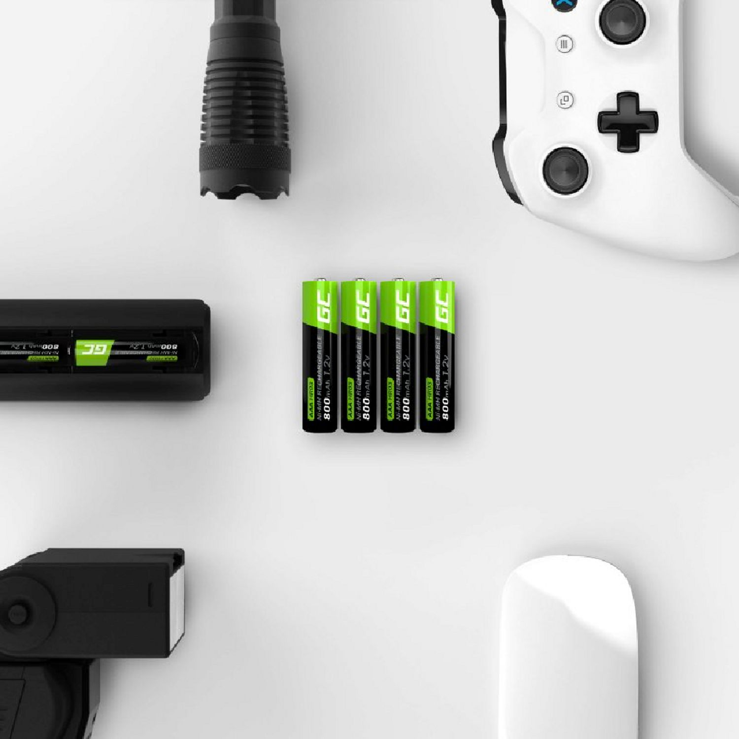 Batterie, caricatore, controller, torcia e mouse su una superficie bianca.