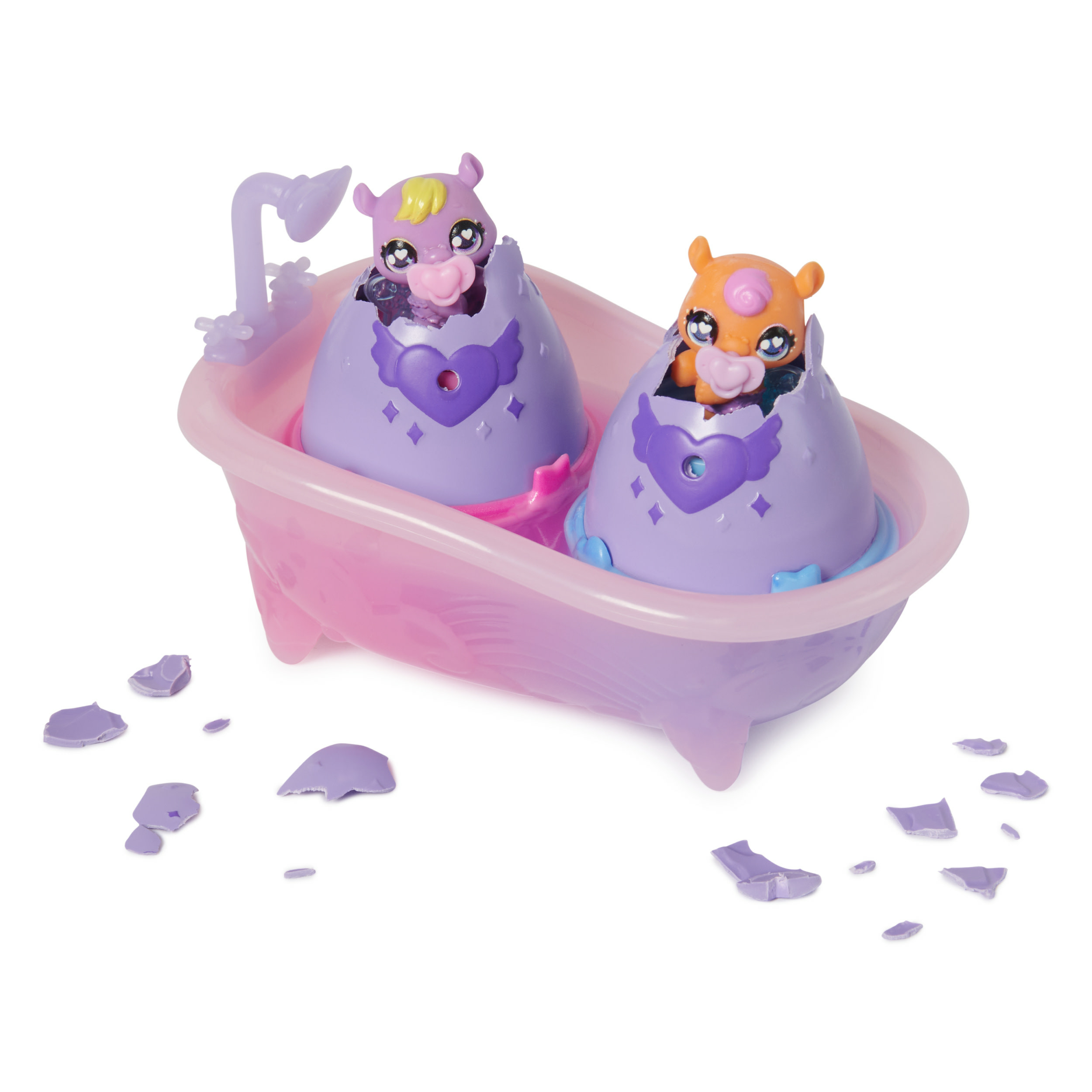 Zwei Spielzeugtiere in Eierschalen in einer rosa Badewanne.