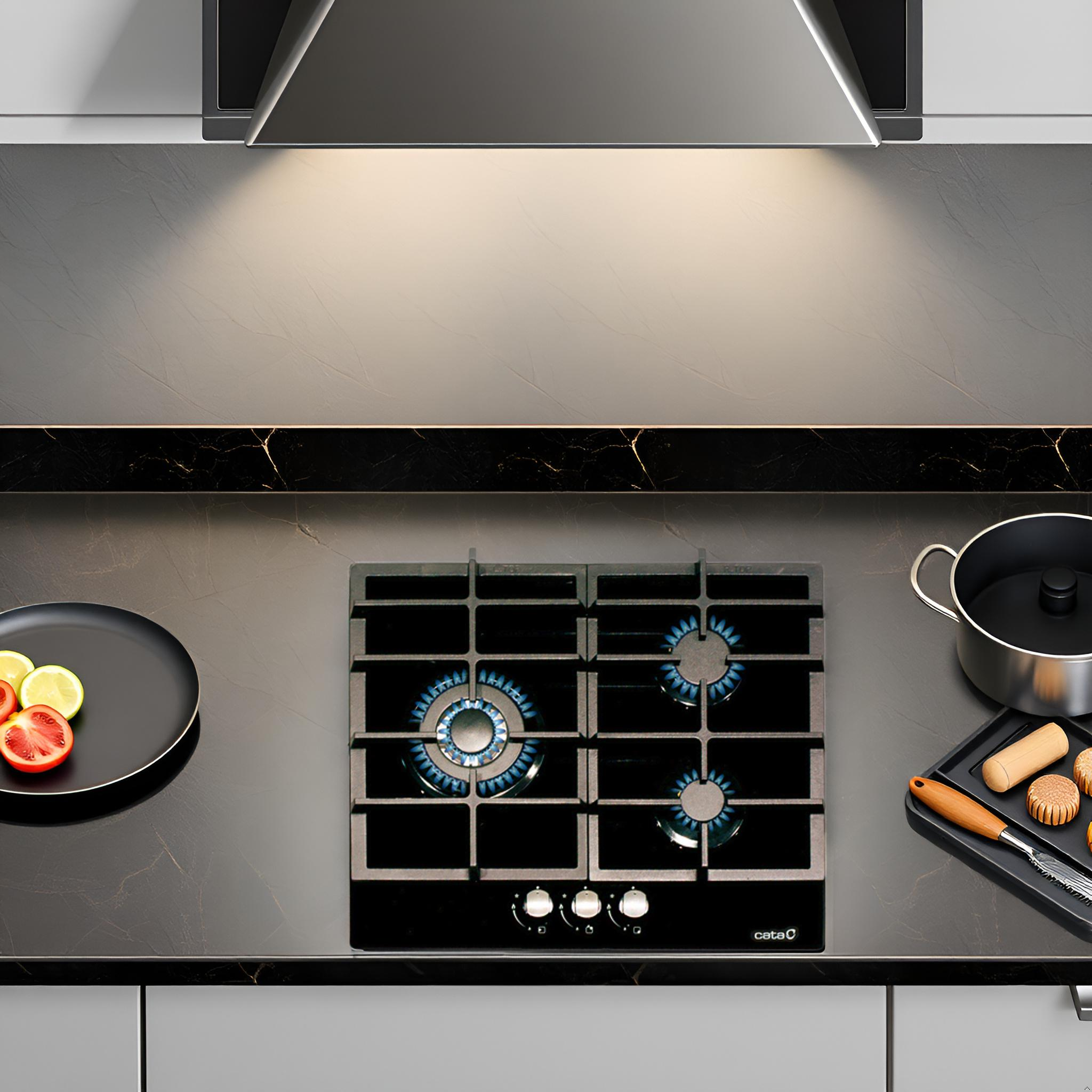 Kuchenka gazowa z niebieskimi płomieniami, czarna powierzchnia i czarny talerz z pokrojonymi pomidorami.