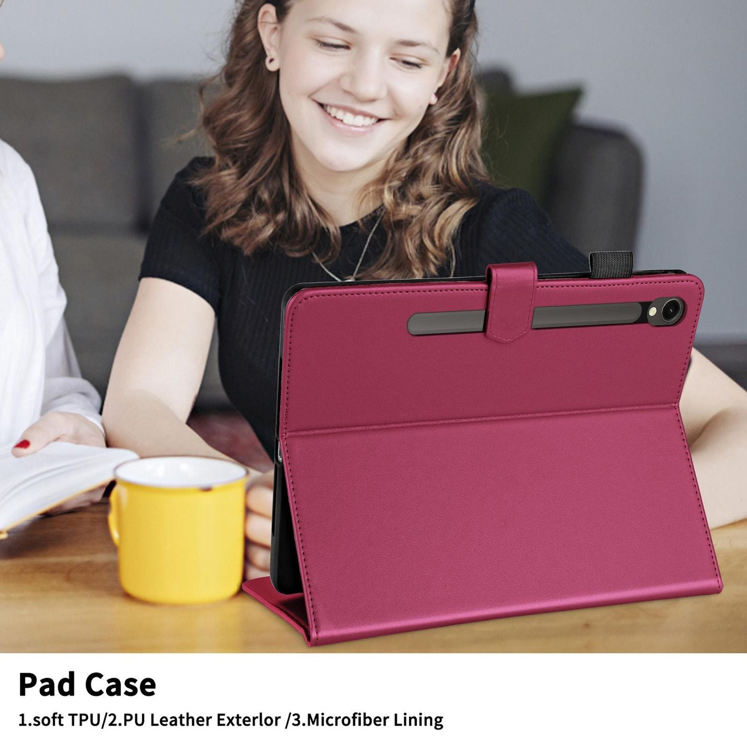 Una mujer y un hombre sentados, con una funda de tableta granate y una taza amarilla. La tableta está abierta.
