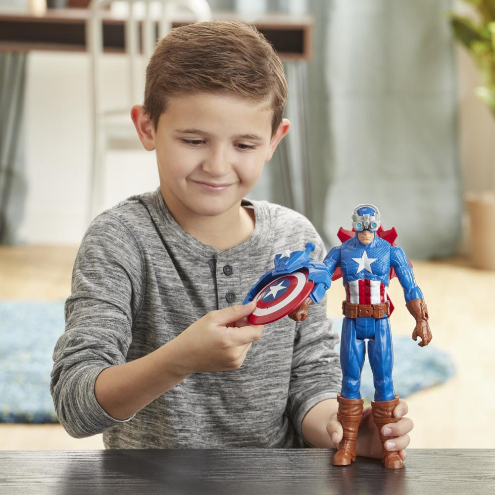 Ragazzo che tiene il giocattolo di Captain America. Sorridente. Abito blu, scudo, occhiali, stivali marroni.