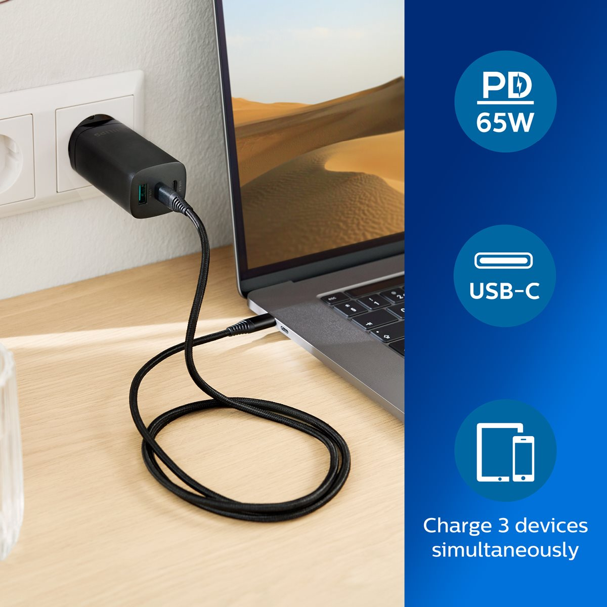 Laptop charging with a black USB charger. Graphics show PD 65W, USB-C, and simultaneous charging.