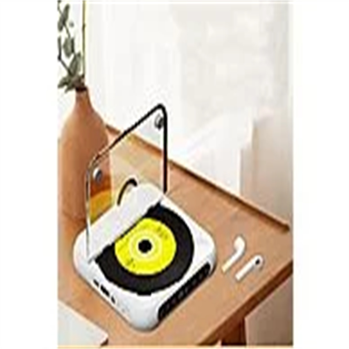 Ein CD-Player auf einem Holztisch, mit einer CD und Kopfhörern. Eine Vase und eine Pflanze stehen auf dem Tisch.