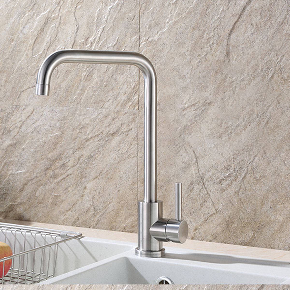 Ein verchromter Wasserhahn mit gebogenem Auslauf. Der Hintergrund ist eine strukturierte, beige Wand.