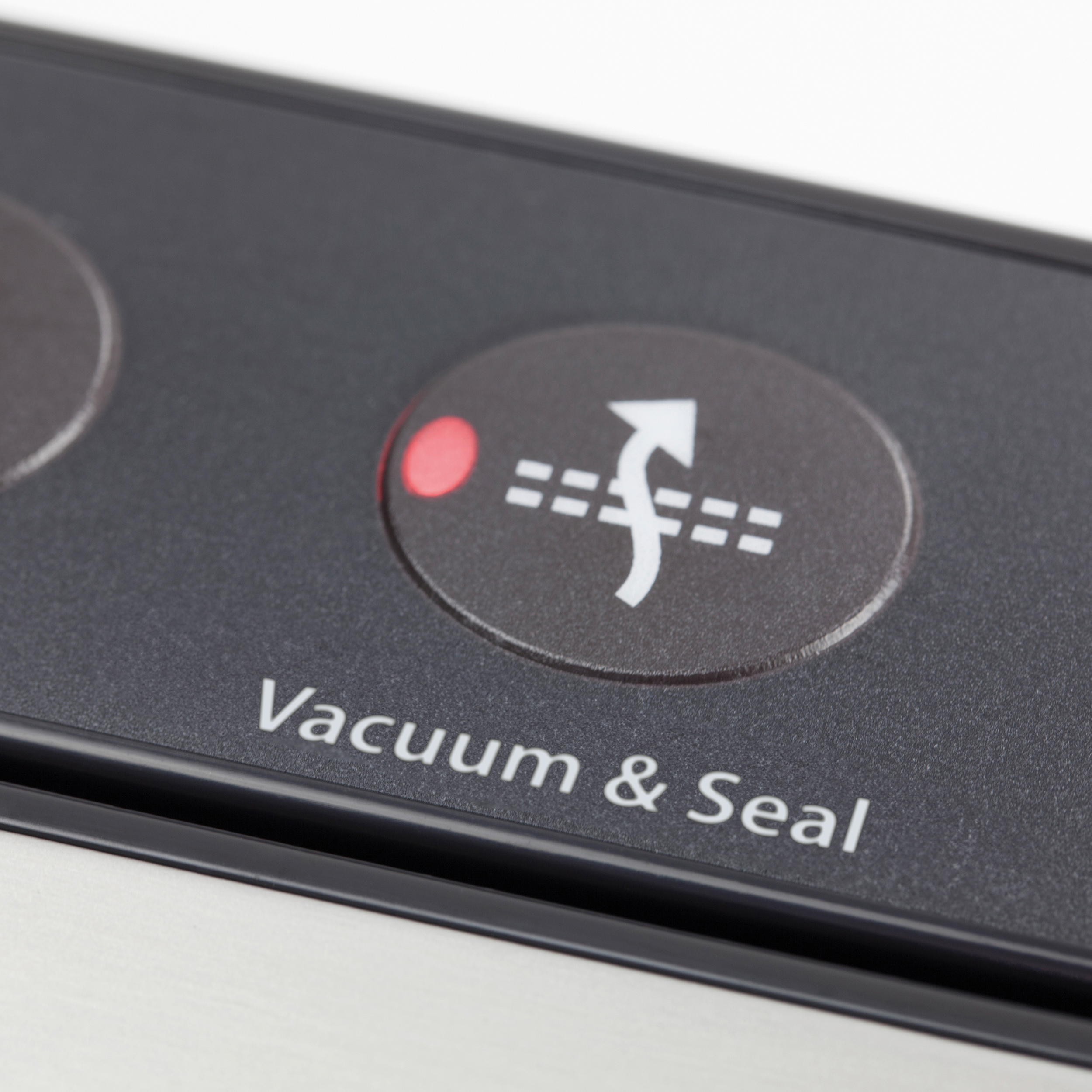 Nahaufnahme einer schwarzen Vakuumierer-Taste mit den Worten 'Vacuum & Seal'.