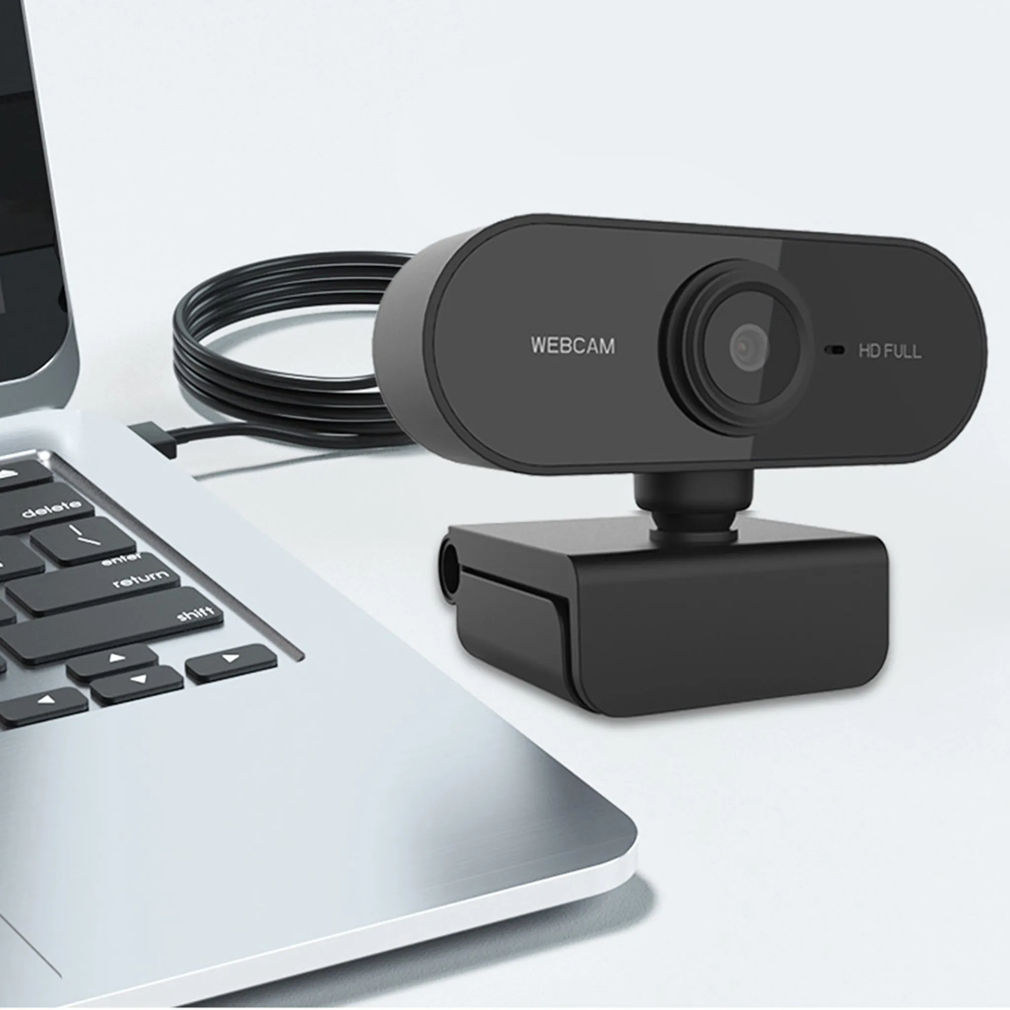 Eine schwarze Webcam, die an einen Laptop angeschlossen ist, auf einer weißen Oberfläche. Text: Webcam, HD FULL.