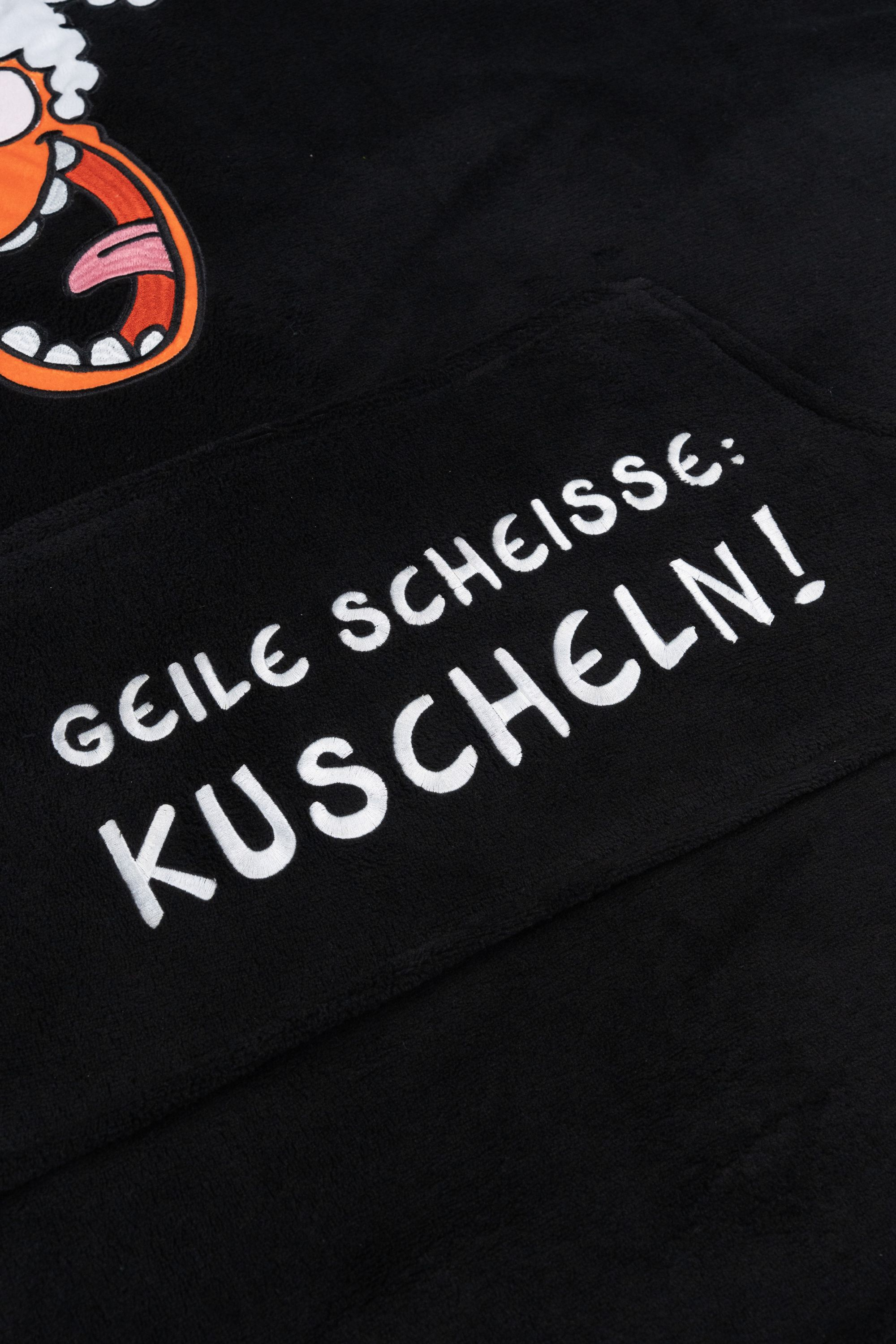 Schwarzer Hoodie mit Cartoon-Gesicht und deutschem Text 'GEILE SCHEISSE: KUSCHELN!'.