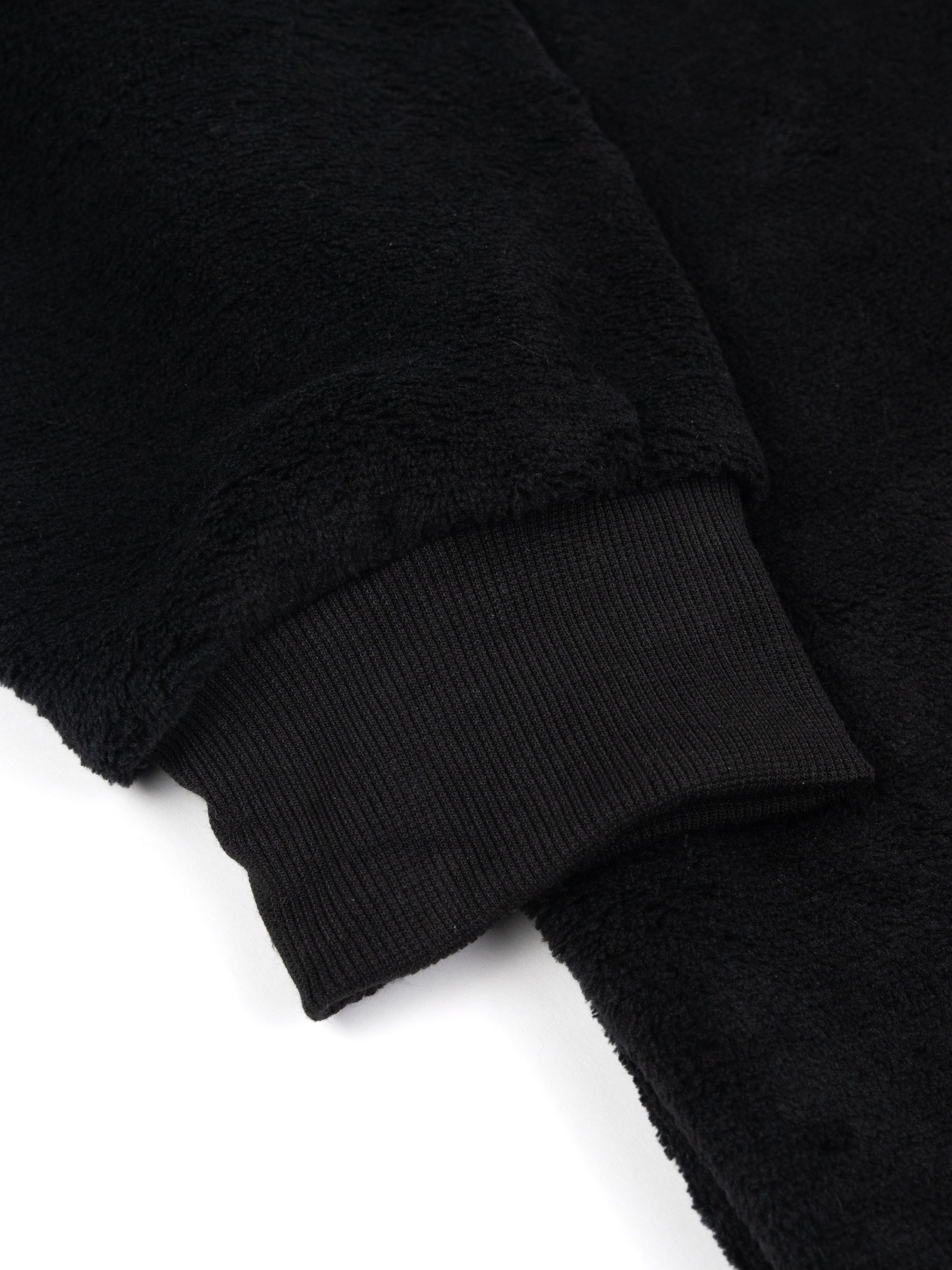 Nahaufnahme einer schwarzen Fleece-Manschette. Die Manschette ist gerippt.
