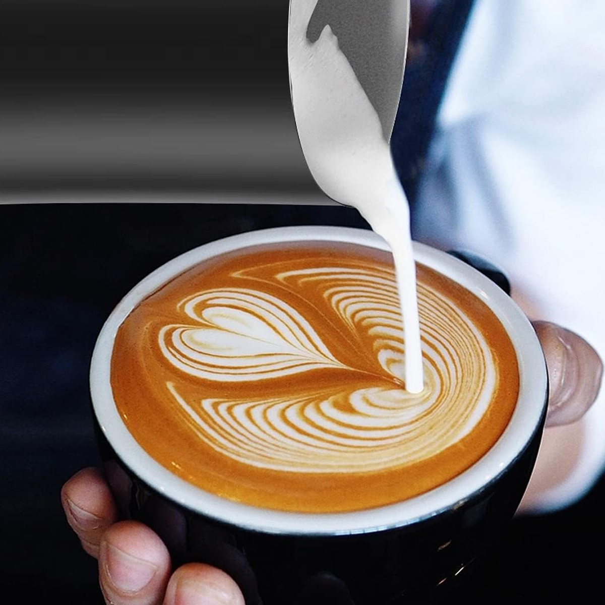 Nahaufnahme von Latte Art in einer schwarzen Tasse. Der Kaffee hat ein Herzmuster.