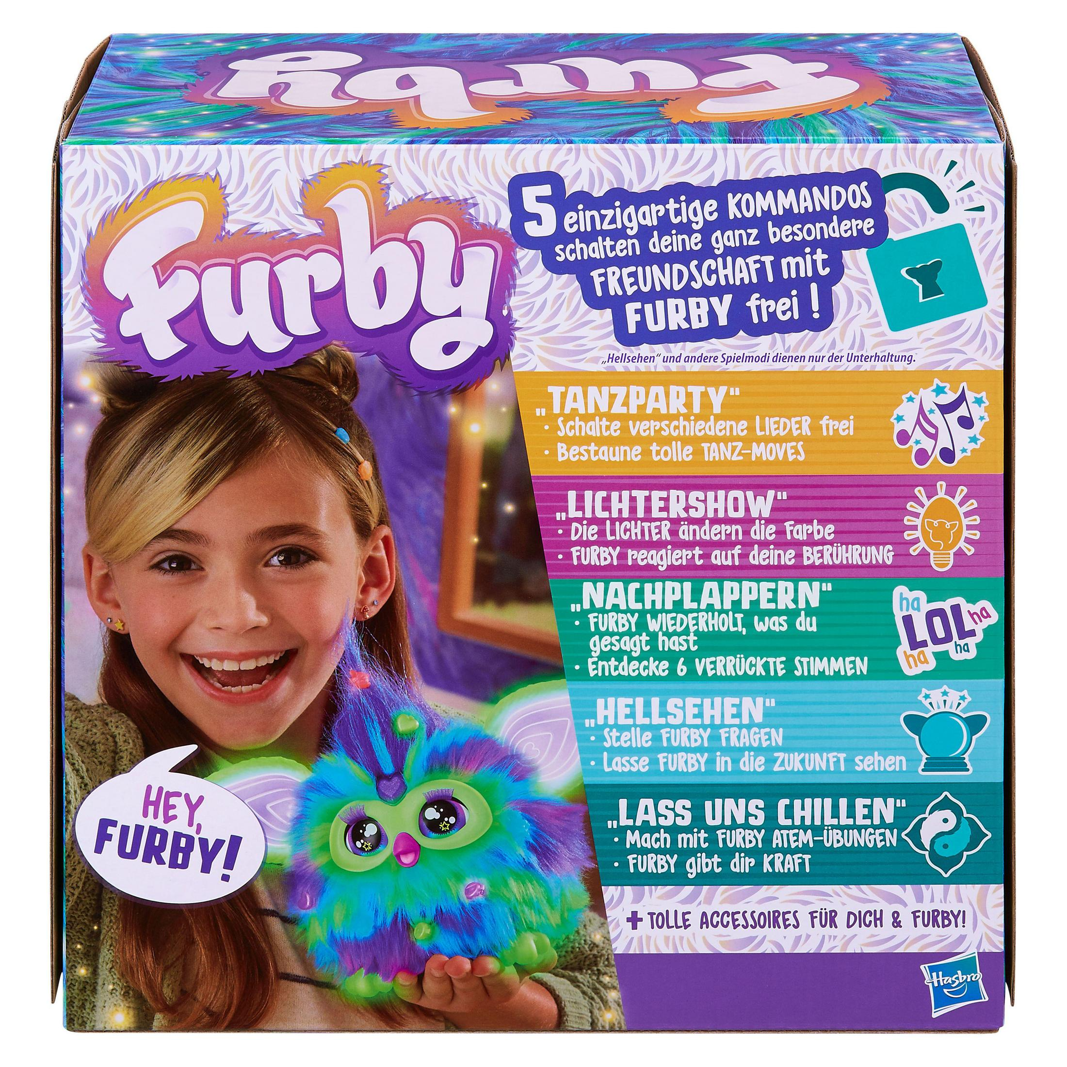 Młoda dziewczyna trzymająca zabawkę Furby. Pudełko zabawki jest w tle.