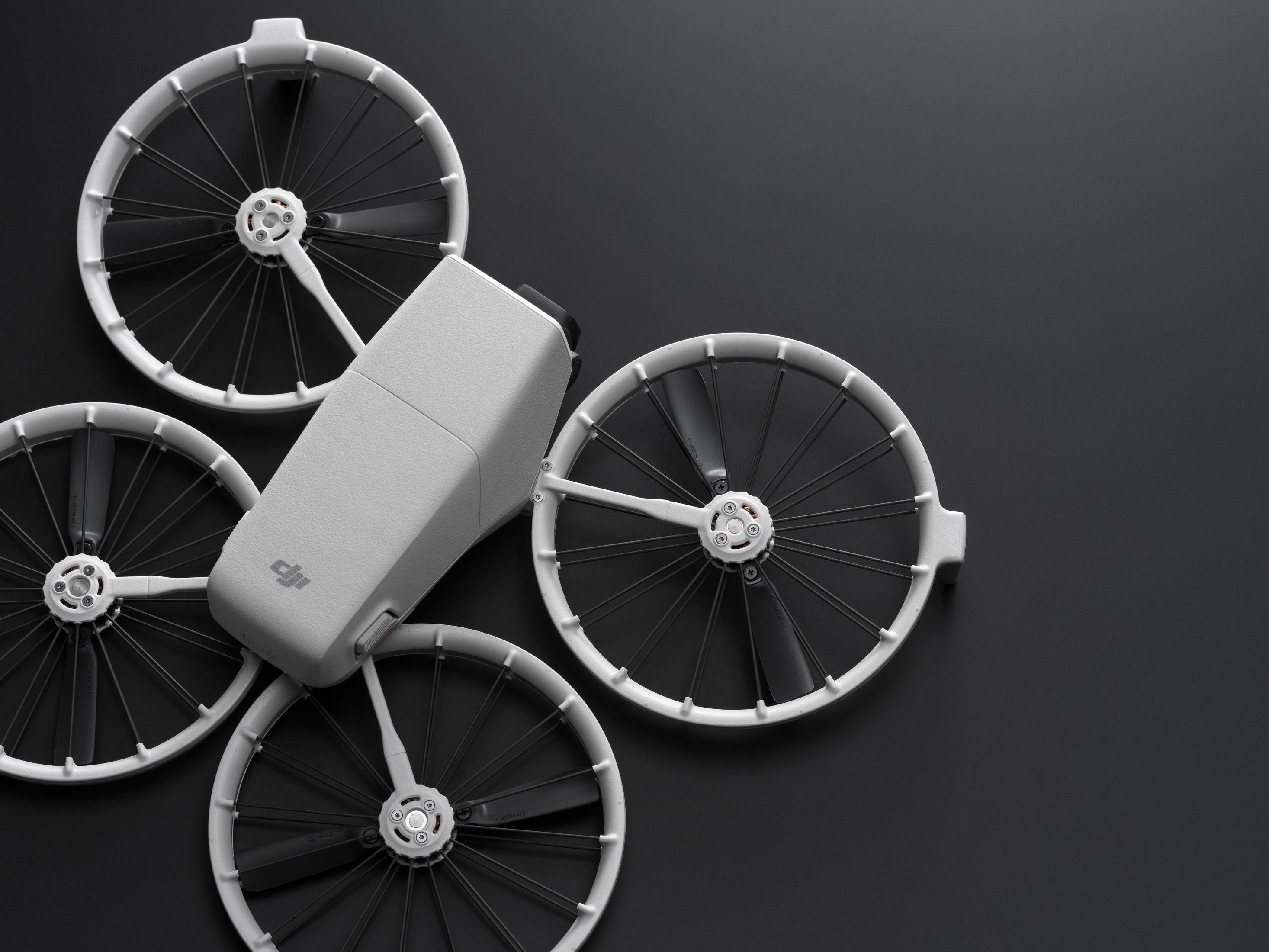 Componentes del dron: cuerpo del dron, hélices y accesorios sobre una superficie oscura.