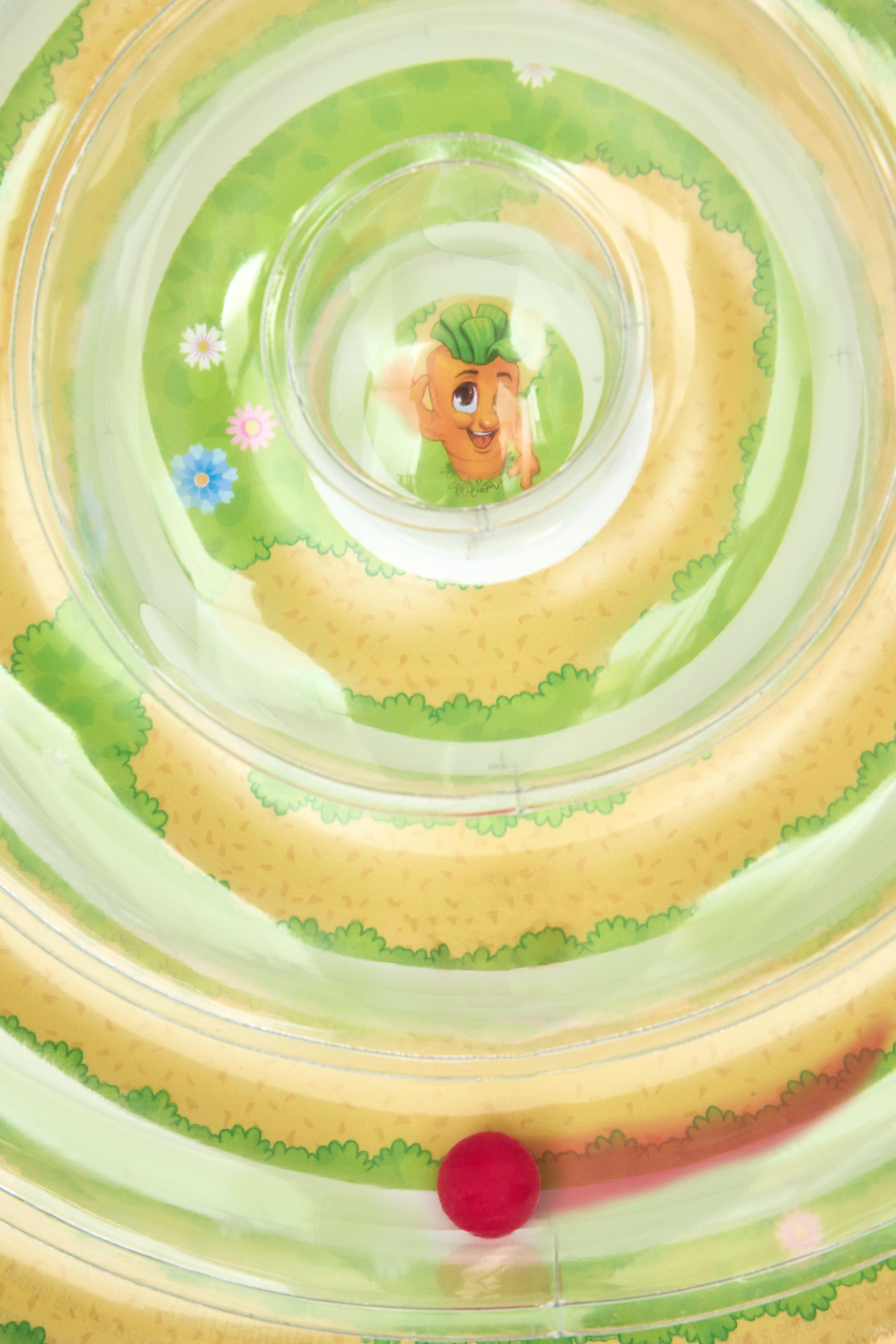 Kinderspielzeug-Labyrinth mit roter Kugel unten und einer Möhrenfigur.