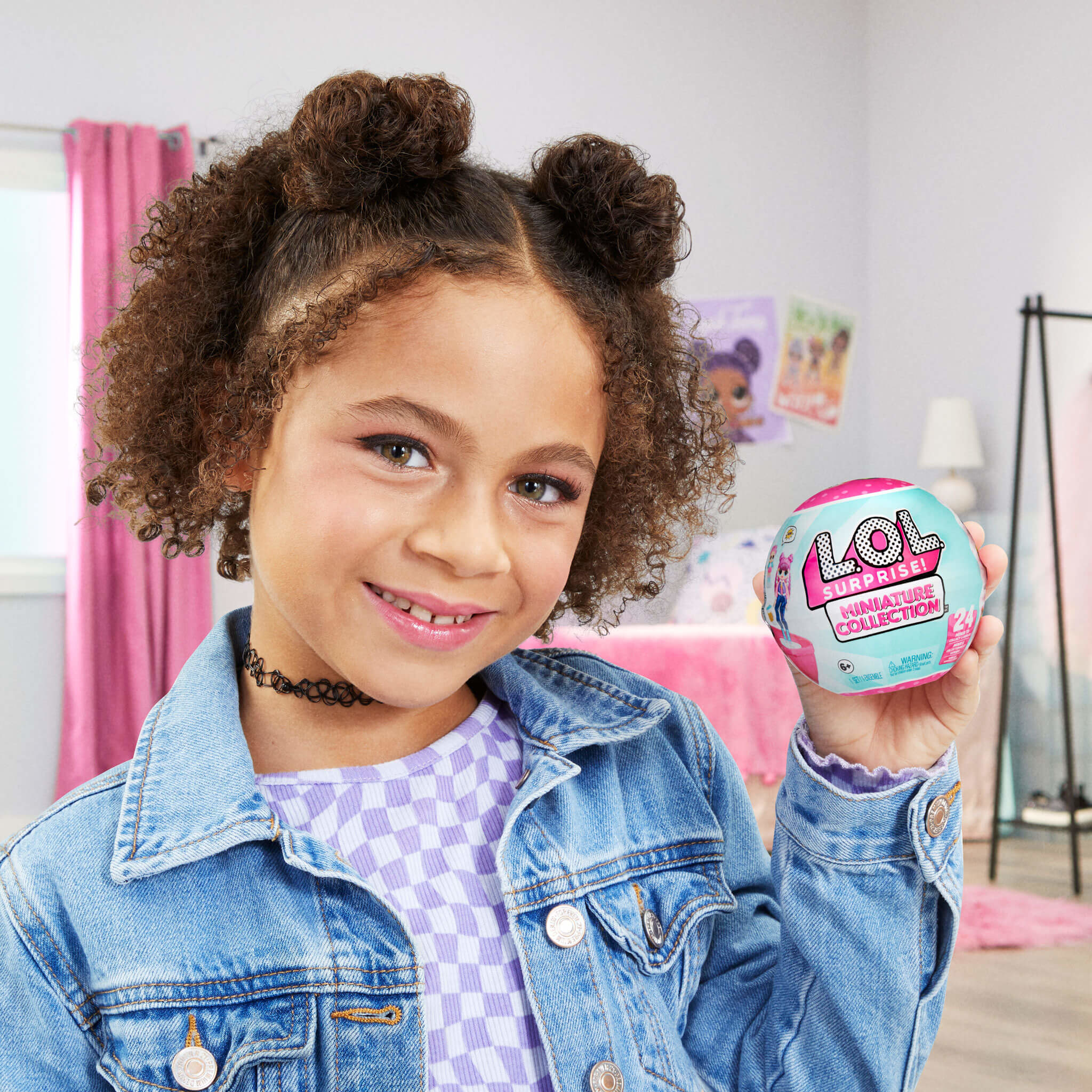 Dziewczyna trzymająca zabawkę, uśmiechając się do kamery.