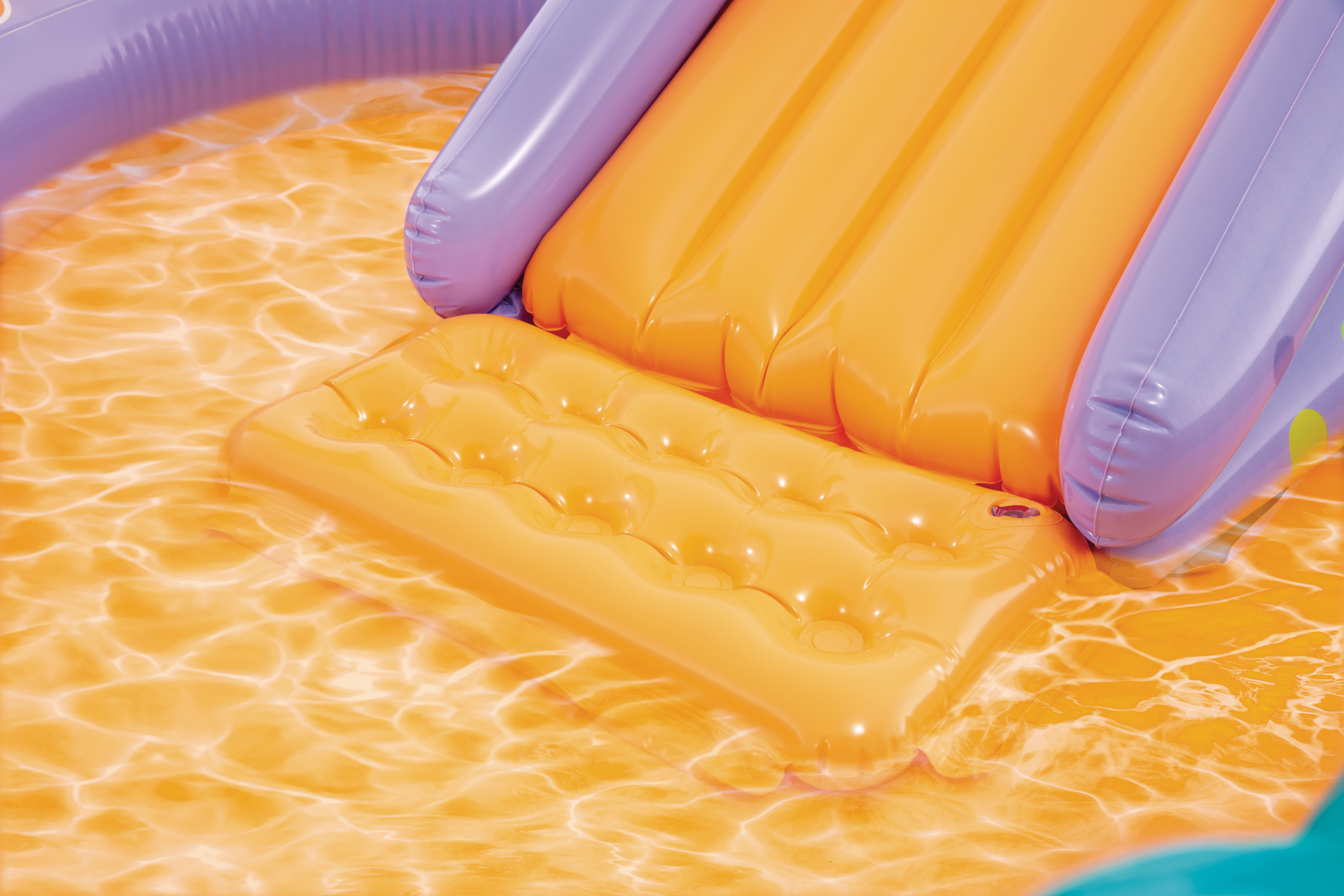 Orangefarbene aufblasbare Rutsche und Matte im Wasser.