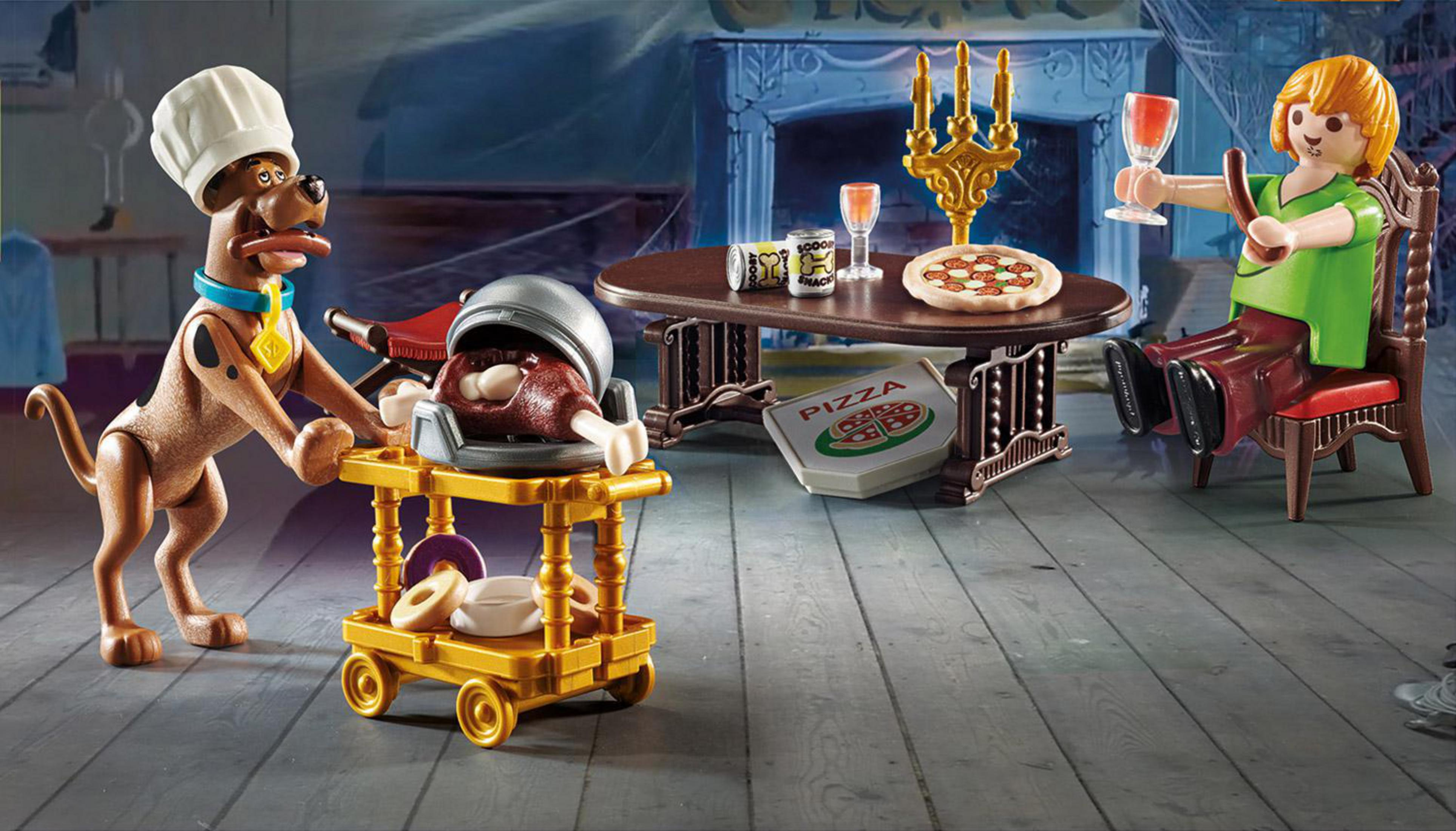 Scooby-Doo i Shaggy przy stole z pizzą, jedzeniem i napojami.