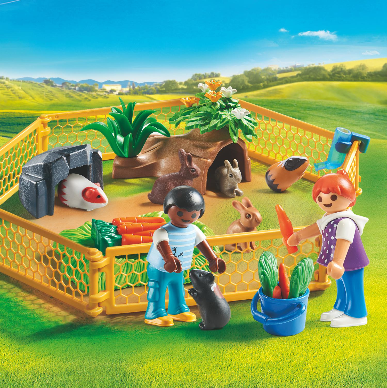 Scena della fattoria Playmobil con personaggi, animali e una recinzione. Una donna sta dando una carota a un ragazzo.