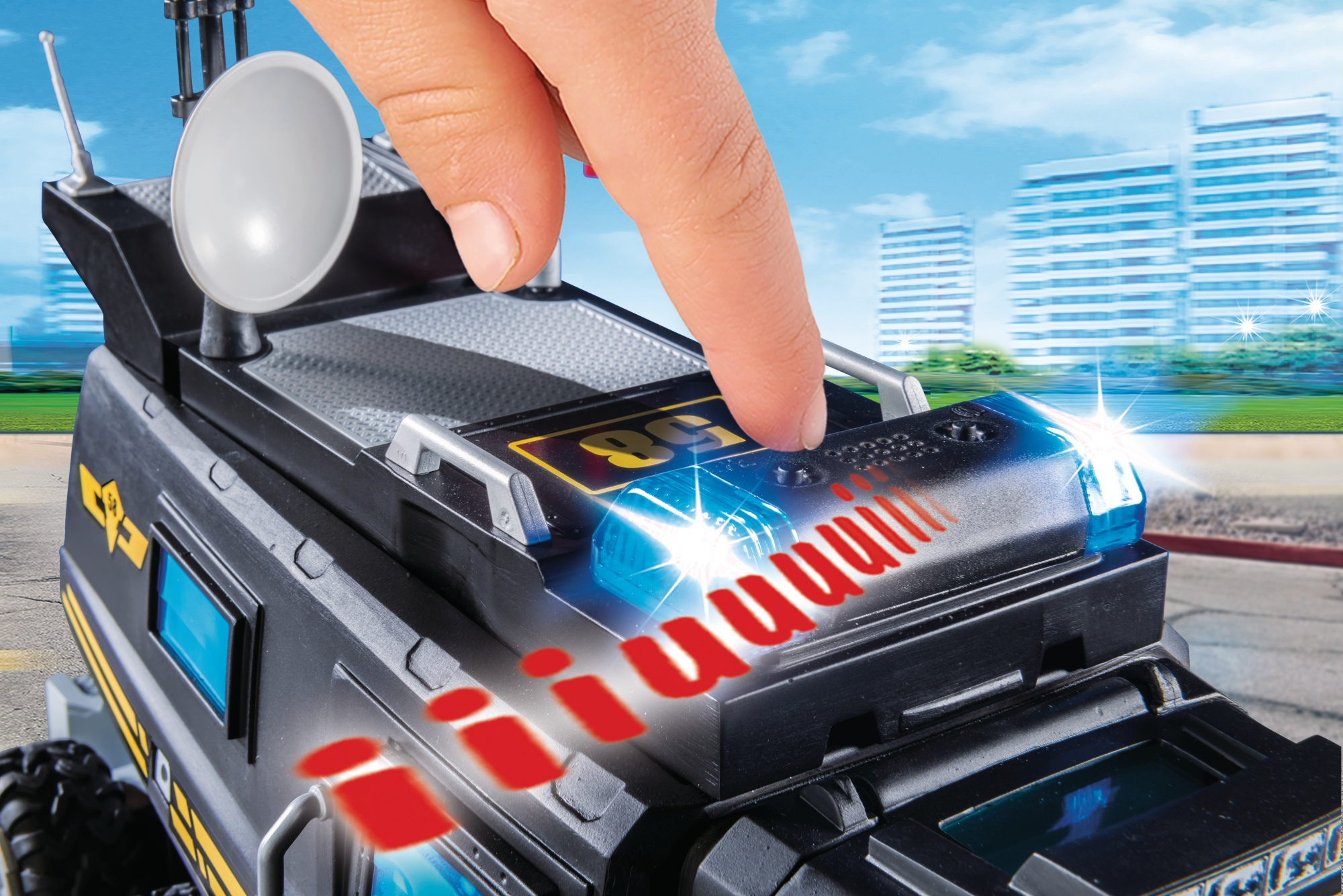 Ręka naciskająca przycisk na zabawkowym pojeździe policyjnym. Pojazd ma migające światła.