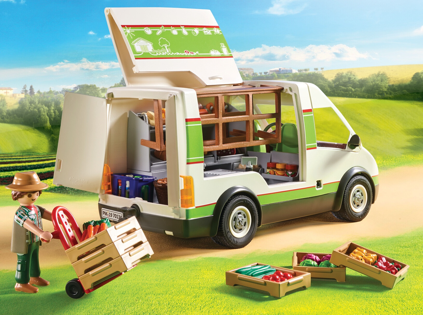 Zabawkowy food truck z otwartym tyłem, figurką rolnika i skrzynkami warzyw na trawie.